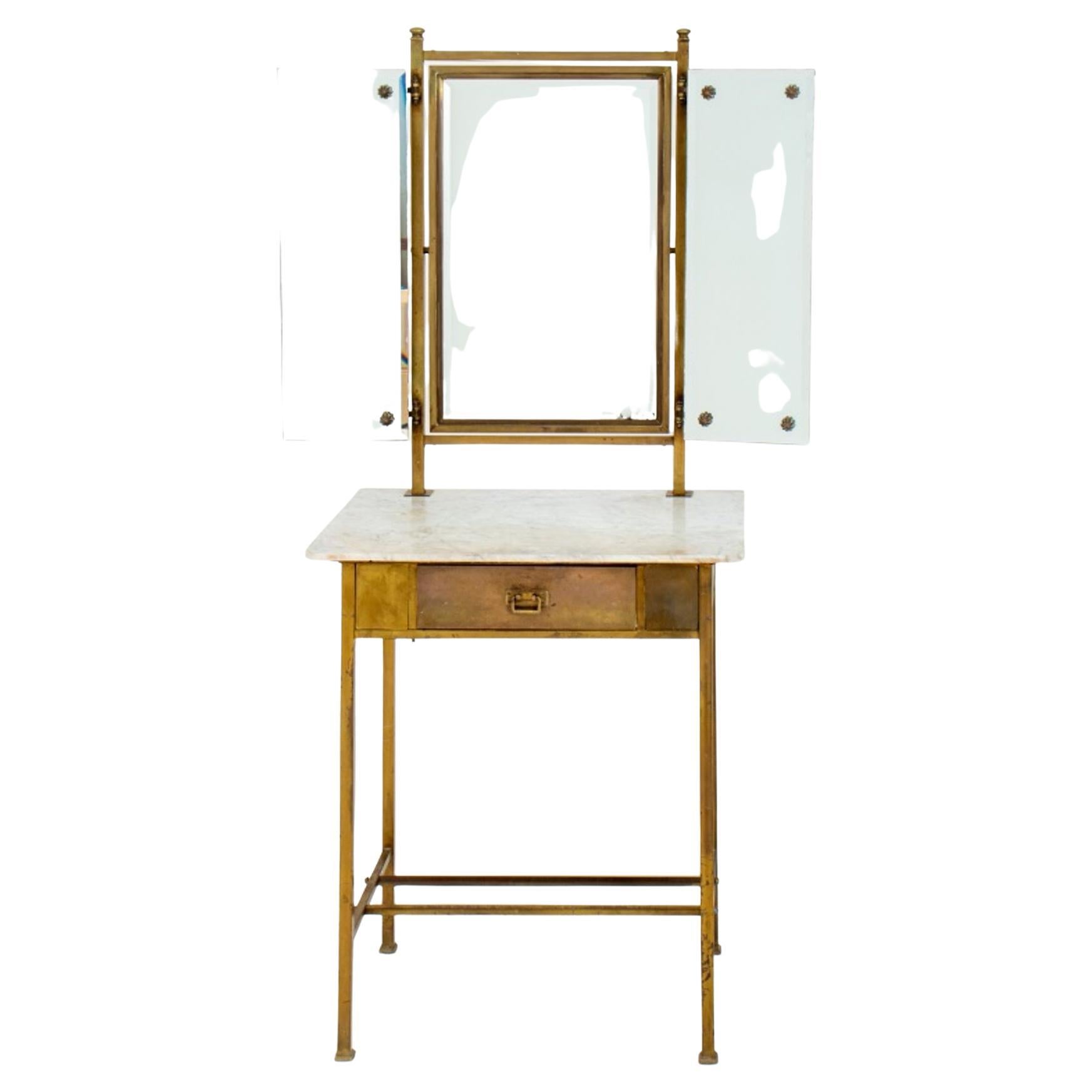 Paul McCobb attributed diminutive brass maquilleuse boudoir vanity desk with folding mirror and marble top above a single drawer. In good vintage condition. Wear consistent with age and use.
Dimensions: 59.5