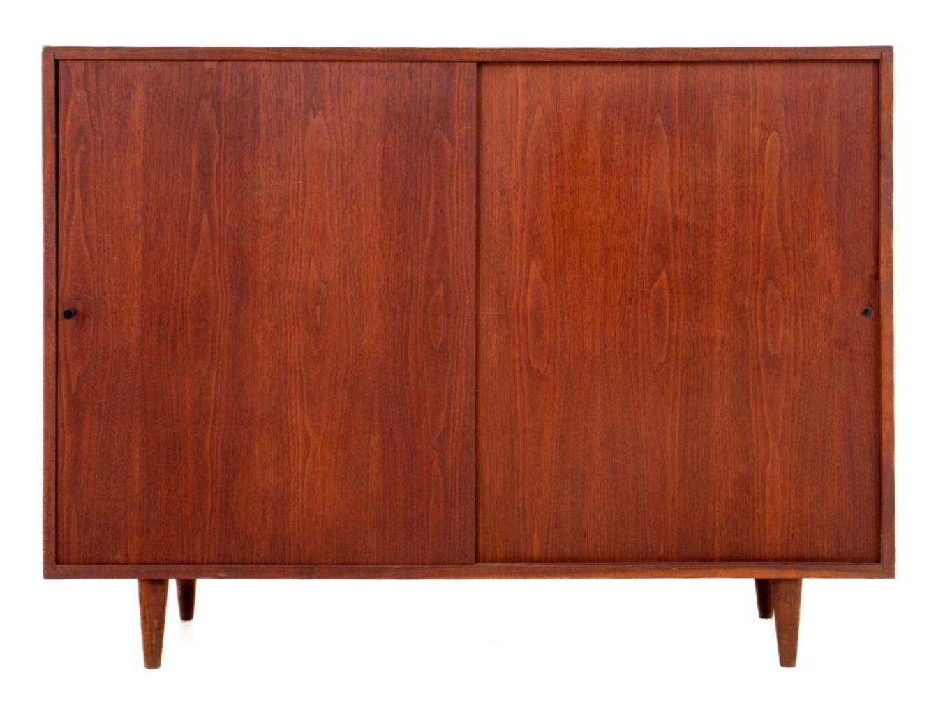 Paul McCobb (American, 1917-1969) attributed possibly for Calvin, Mid Century modern walnut 2 sliding door cabinet with black cylinder knobs, apparently unmarked, tapering cylindrical wooden legs. Measures: 35.5