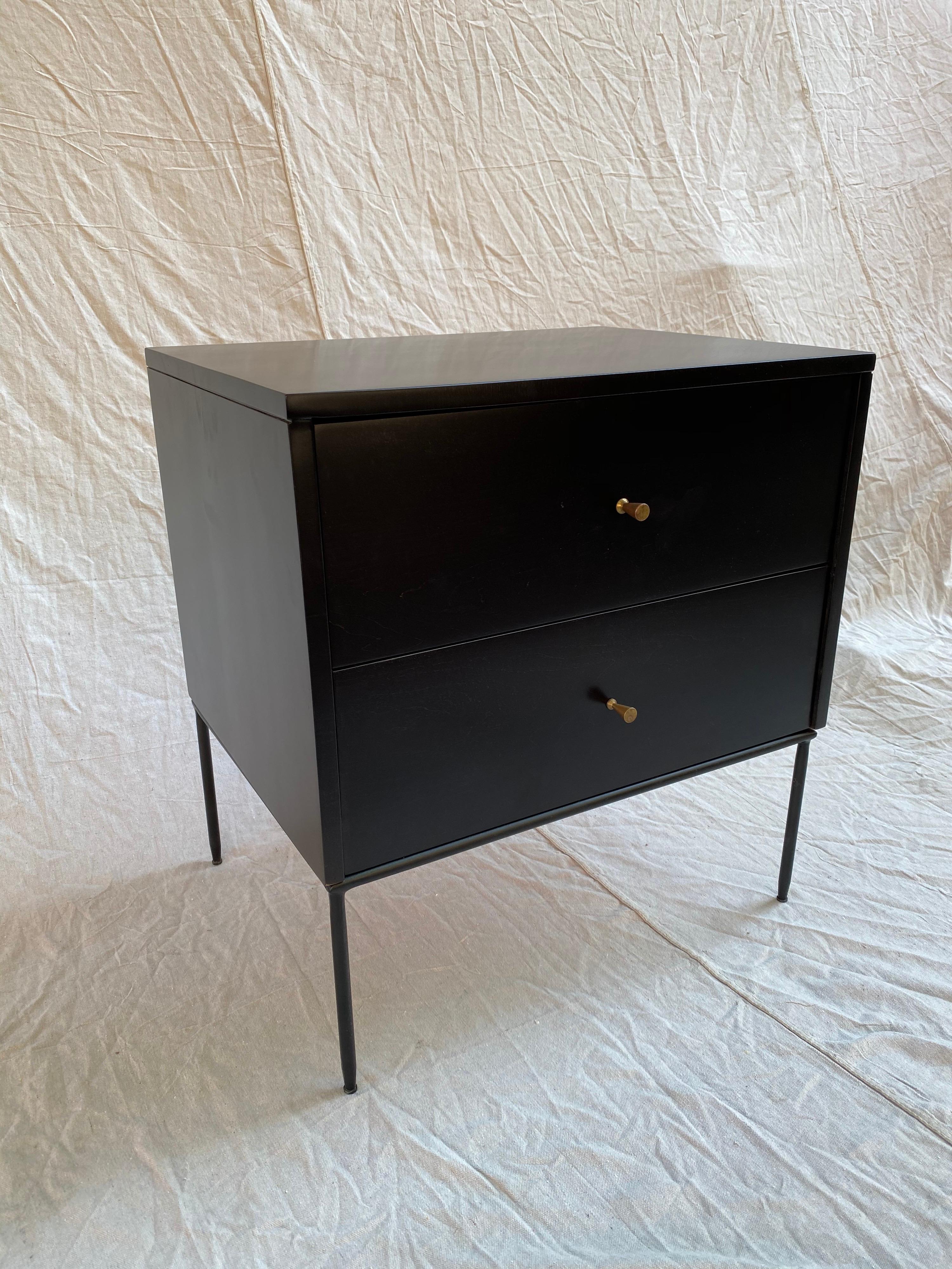 Paul McCobb 2 drawer cabinet on metal base. Newly refinished in a satin black finish. Brass cone handles are currently on the cabinet. I have vintage aluminum rings and vintage 