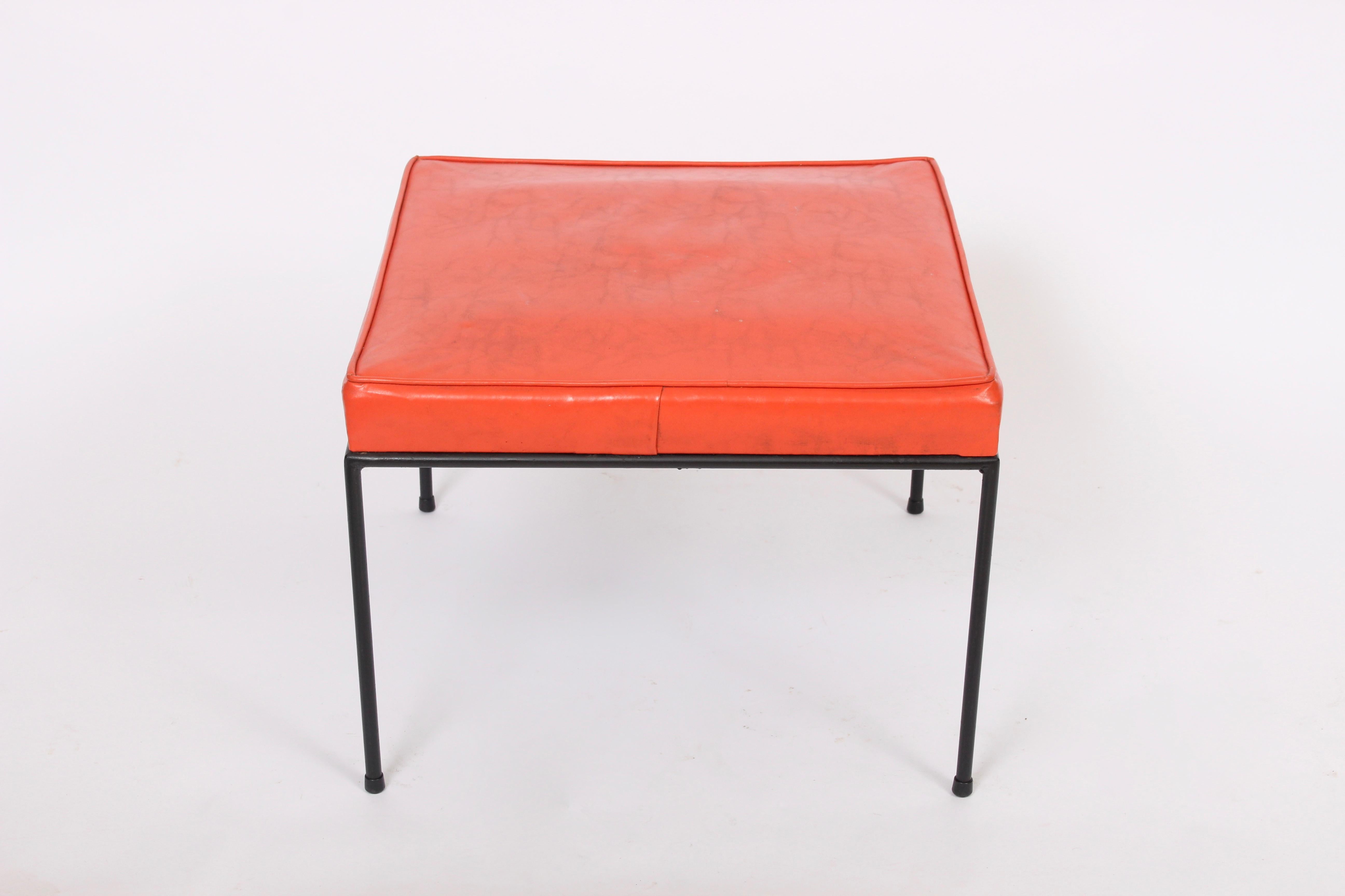 Classic American Mid-Century Modern Paul McCobb red upholstered wrought iron ottoman. Featuring an open black iron framework in original condition with original Red vinyl upholstery and glides. Parcel shipping also available, please inquire