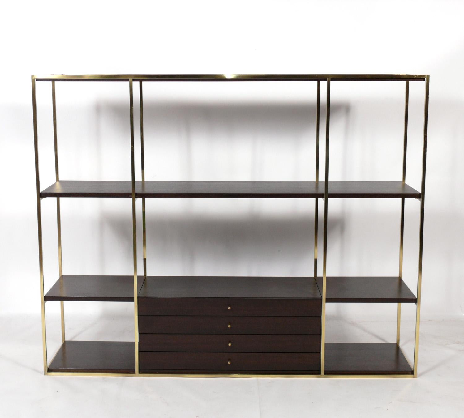 Clean Lined Mid Century Modern étagère or bookshelf, designed by Paul McCobb for Calvin, American, circa 1950s. Signed inside drawer. It has been completely restored in a deep brown color finish and the brass portions have been polished and
