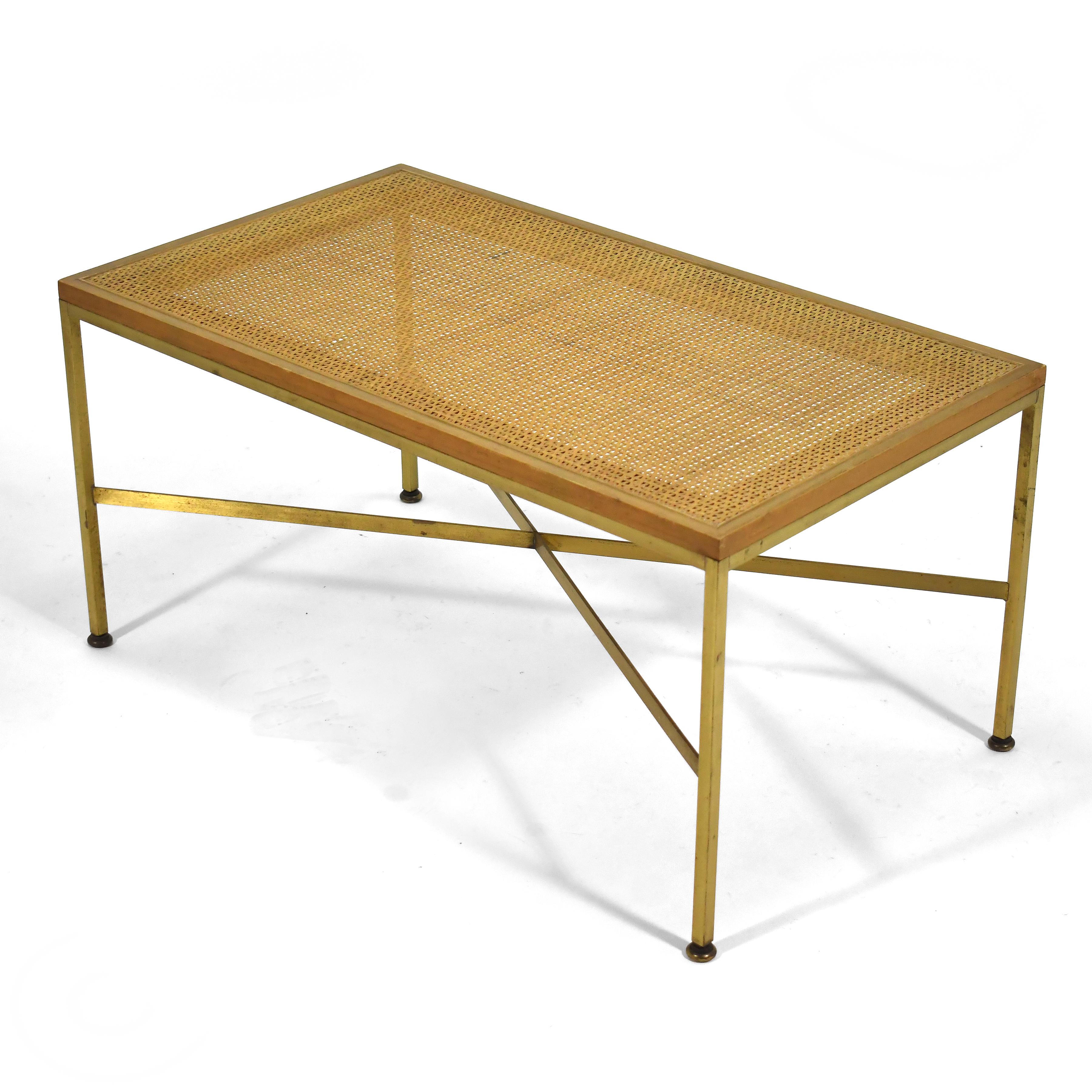 This lovely model 7709 Paul McCobb bench, is light and elegant. The brass bass with its X shaped stretchers supports a walnut and cane top. Comfort can be increased with the addition of an upholstered cushion, and while designed as a bench, this