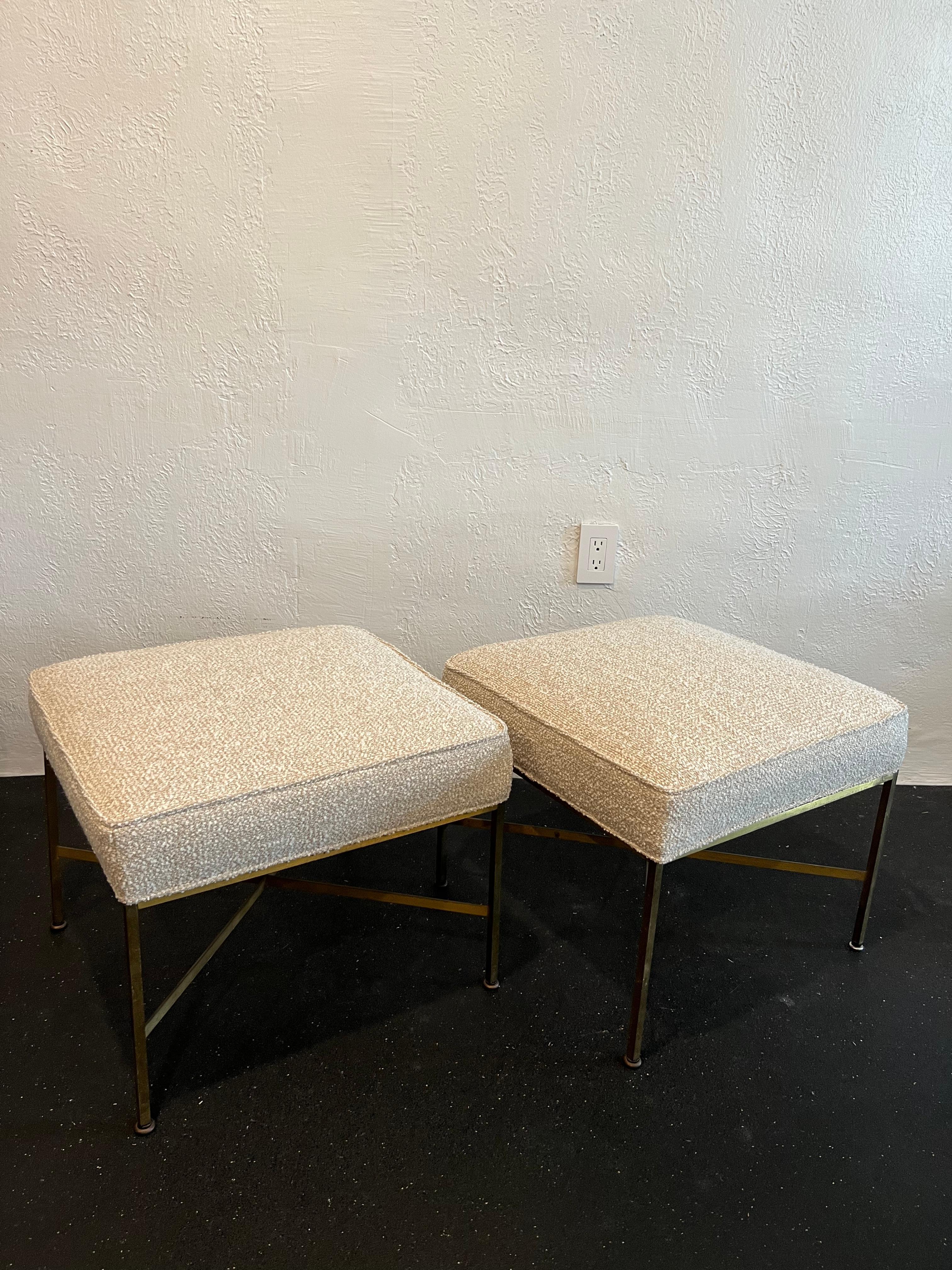 Pair of Paul Mccobb brass x-base stools. Reupholstered in an earth toned boucle. Beautiful patina to the brass frame. A few hairline fractures near the bottoms of the legs typical with these stools and 3 glides have been replaced throughout the