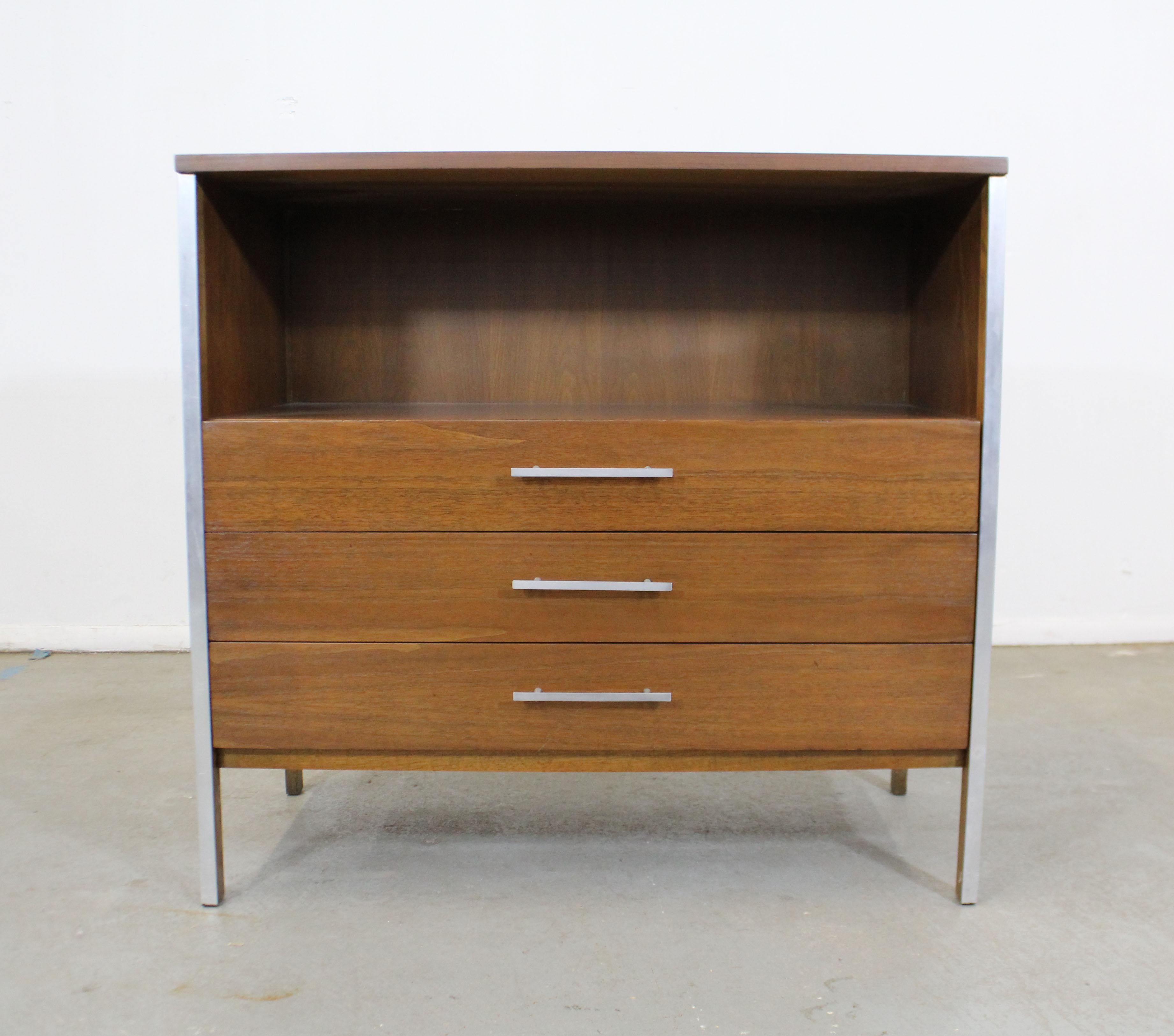 Offered is a vintage Mid-Century Modern bachelor chest by Paul McCobb for Calvin Group. It is made of walnut with aluminum inserts. It is in excellent condition for its age. Has been refinished, has some slight edge wear and a few scratches, but