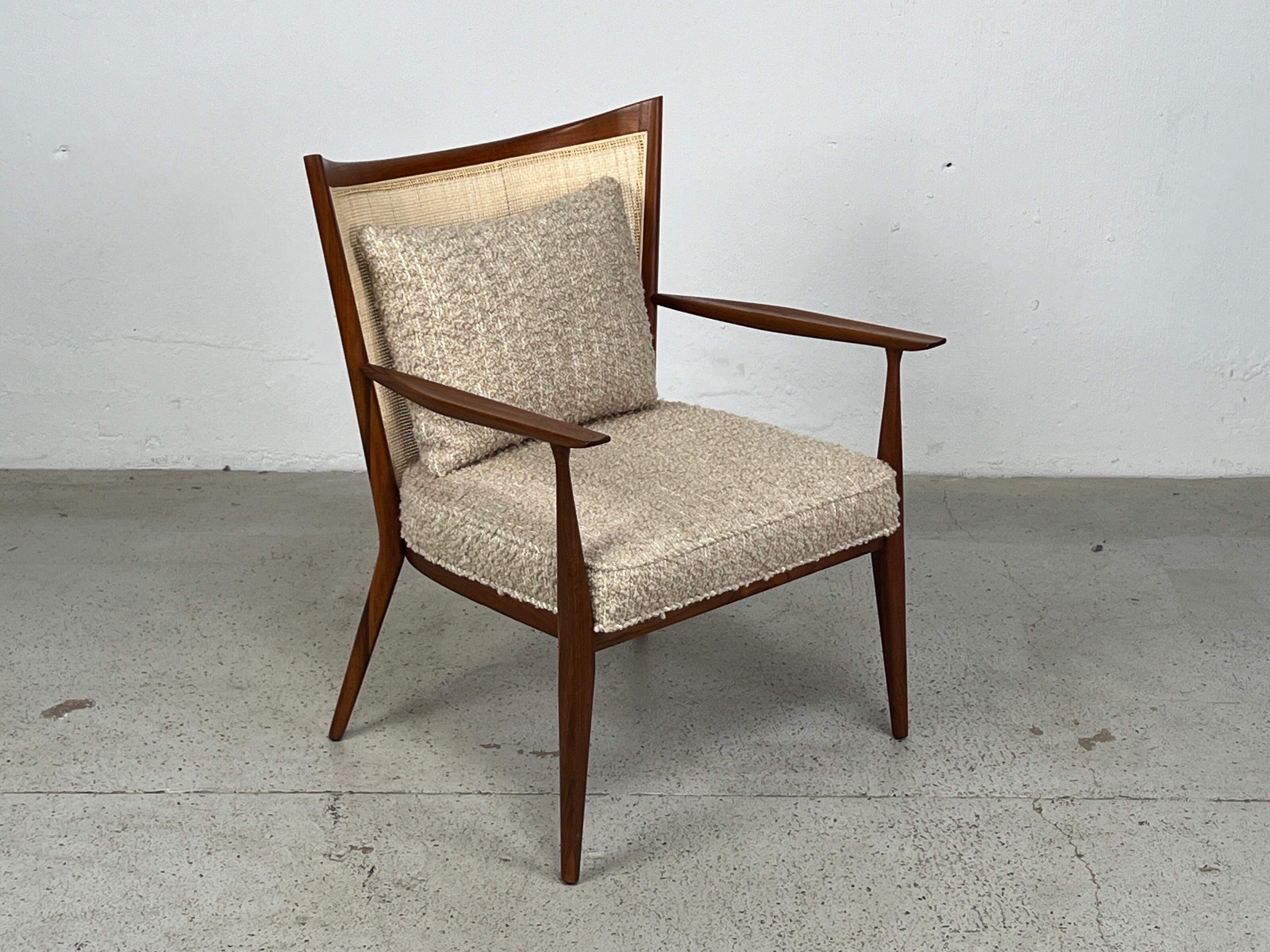A walnut and cane lounge chair designed by Paul McCobb. Fully restored.