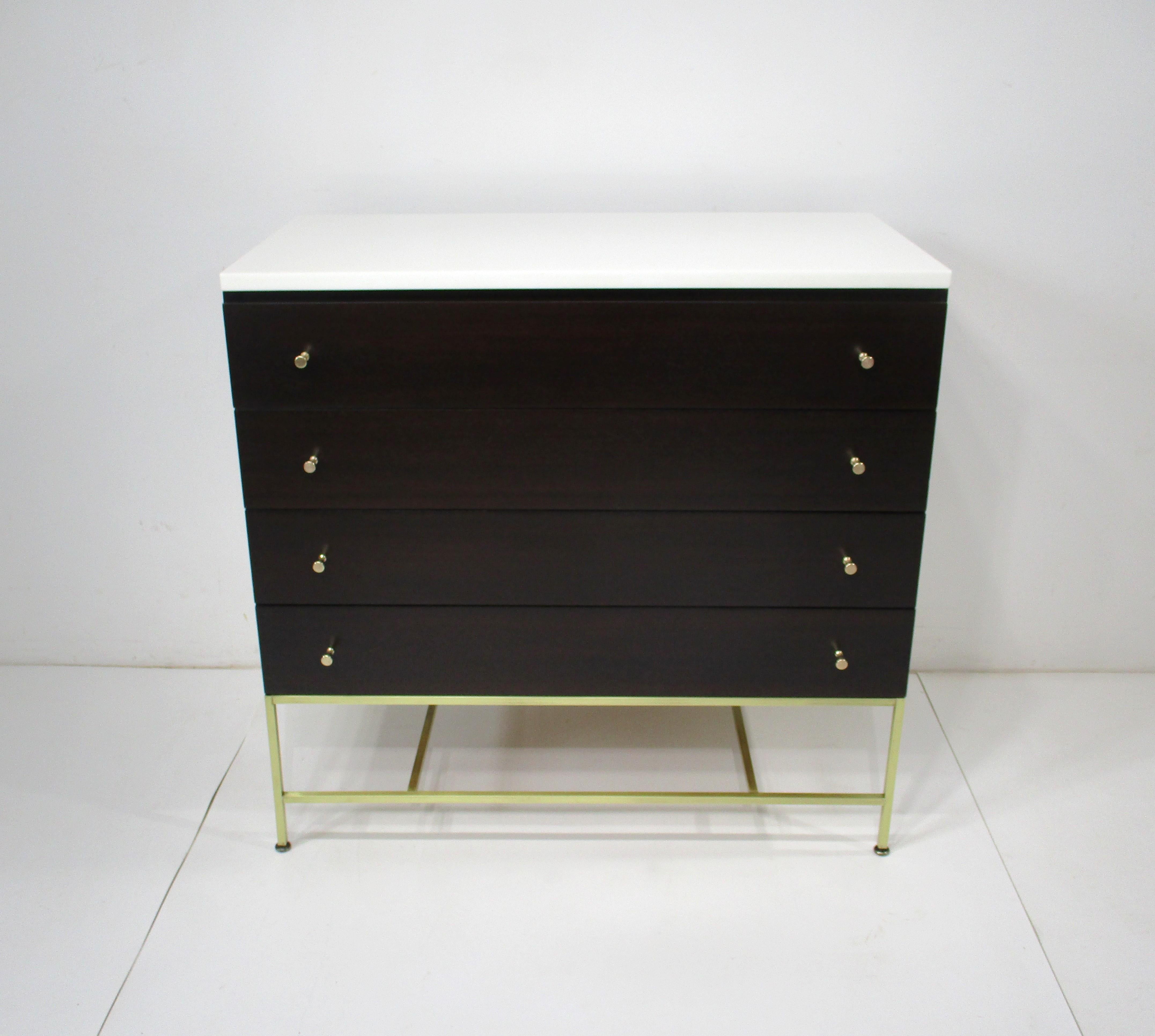 This is one of the best well crafted and tightly tailored pieces by the iconic designer Paul MCobb . Featuring brass pulls and leg structure contrasting with the dark mahogany and having four drawers makes this a statement piece in any room setting