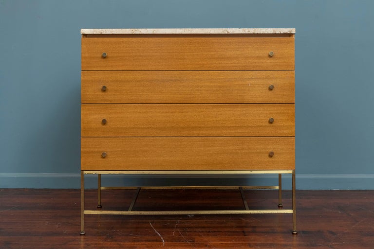 Paul McCobb design chest of drawers for his Irwin Collection by Calvin. 
Classic American Mid-Century modern design and very functional for everyday use. Made from bleached mahogany with a travertine stone top on a brass plated base, labeled.