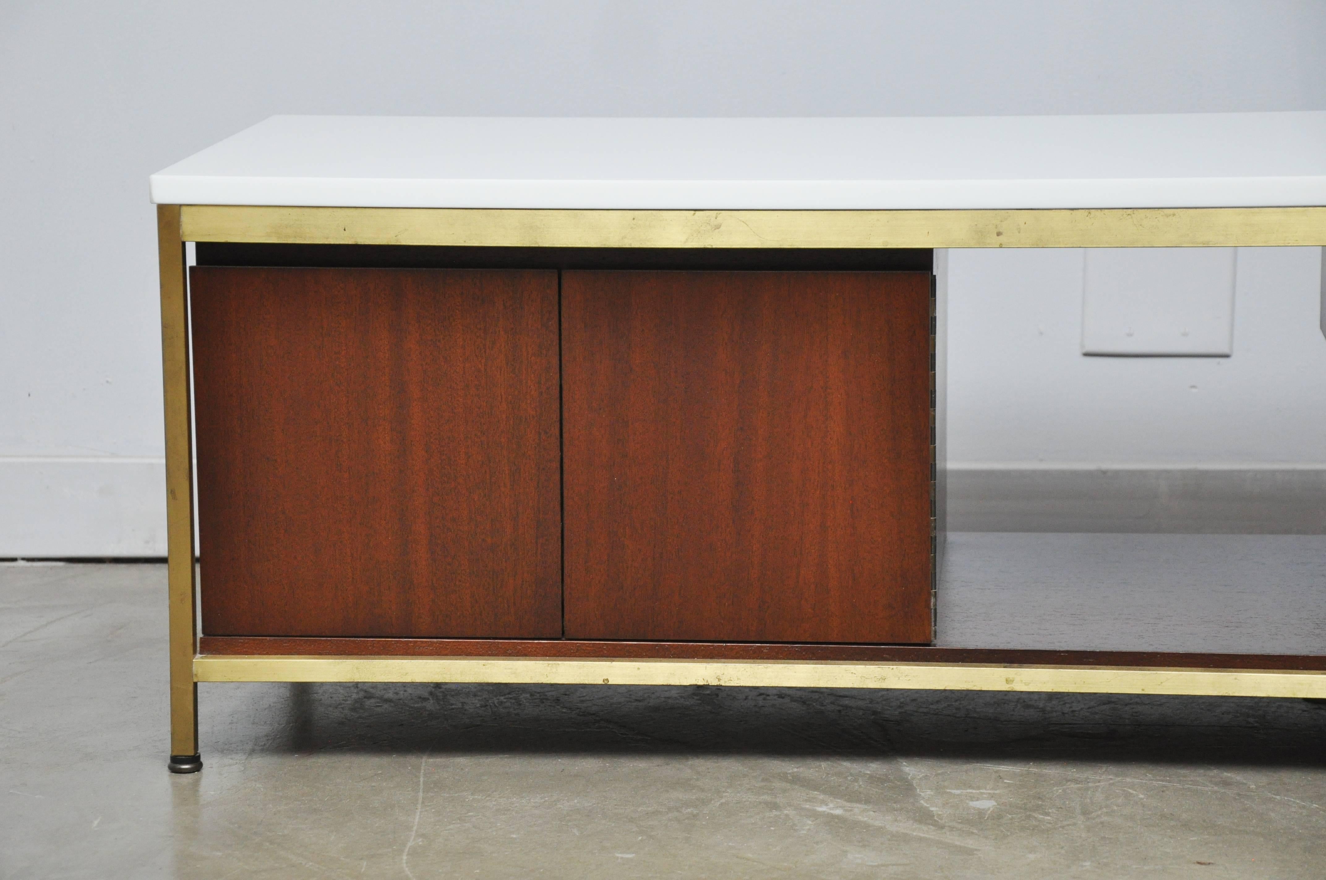 Paul McCobb coffee table or media console for Calvin Furniture. White vitrolite glass top on brass frame. This rare piece is perfect for use as an entertainment centre for flat screen tv, or as coffee table.
    