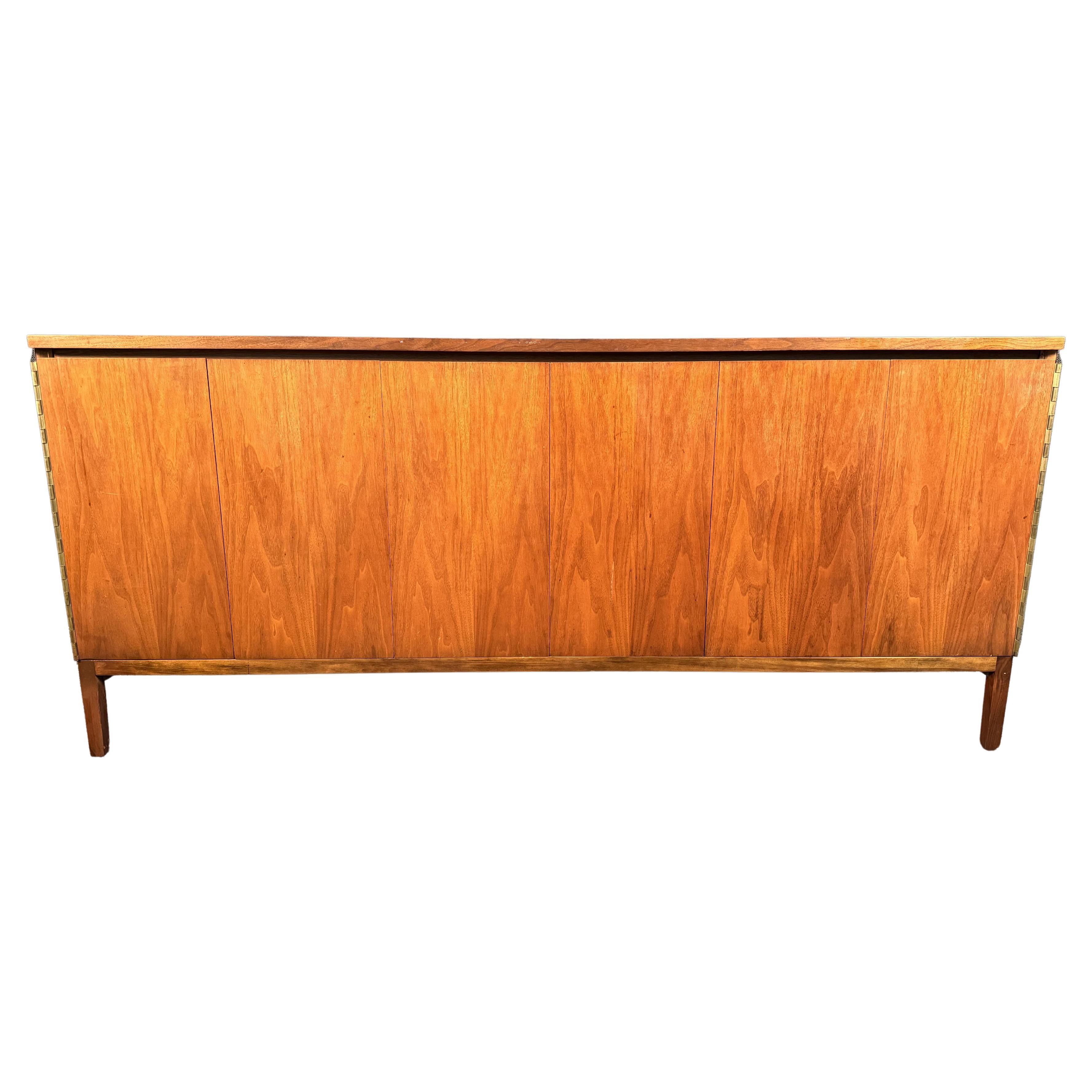 Bellissima credenza MCM progettata dal designer americano Paul McCobb (1917-1969) per Calvin. Realizzato a Grand Rapids, Michigan, questo mobile ha un piano in legno, due ante a fisarmonica e poggia su gambe dritte in legno. L'interno della credenza