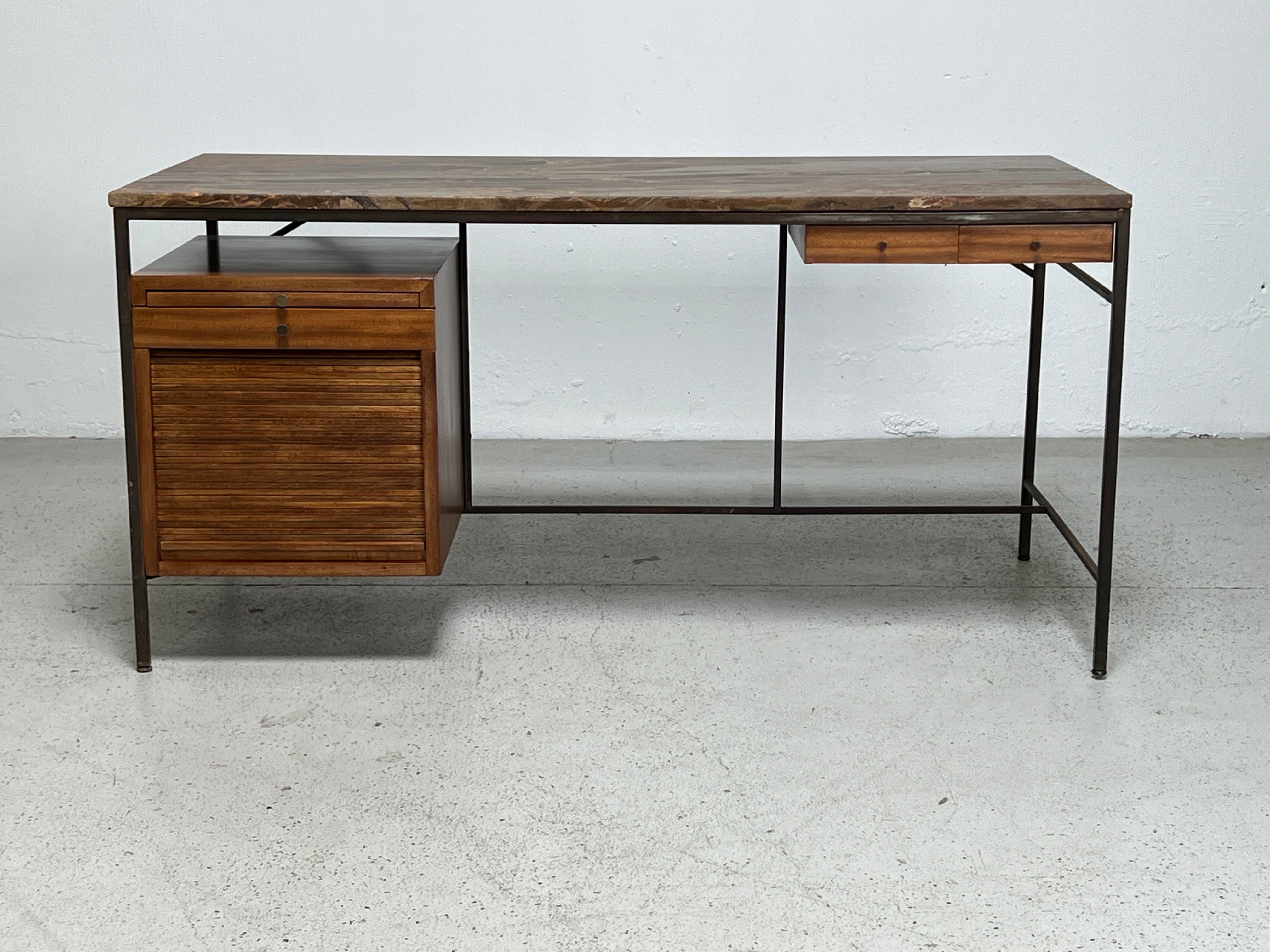 A rare brass and mahogany desk with stone top designed by Paul McCobb for Calvin. 