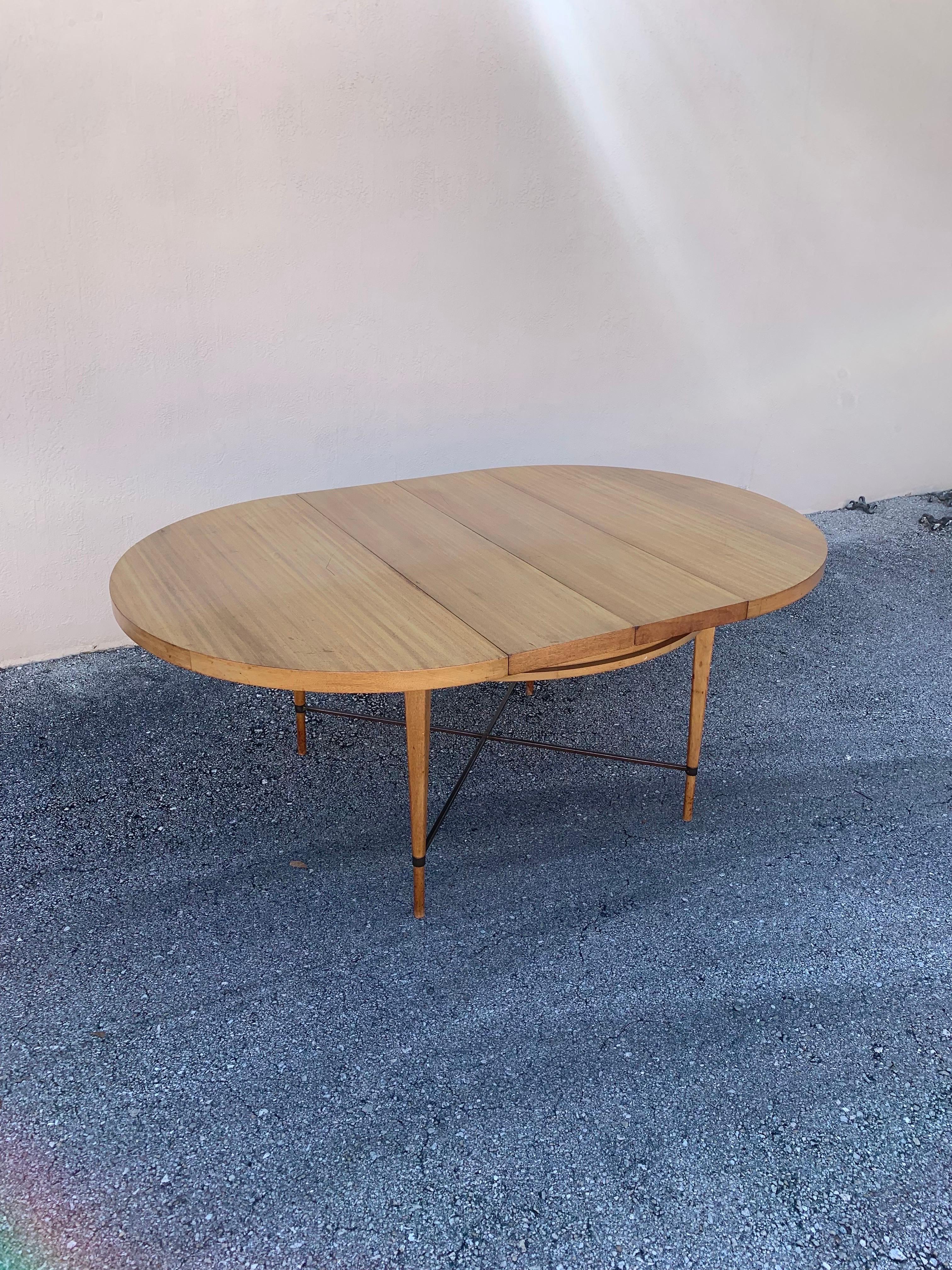 For you interest is a dining table designed by famed designer Paul McCobb. Produced by Calvin as part of the Irwin Collection. A round table with out the leafs and a larger dining table with the leafs. Two leafs total at 12” each. 

Table is