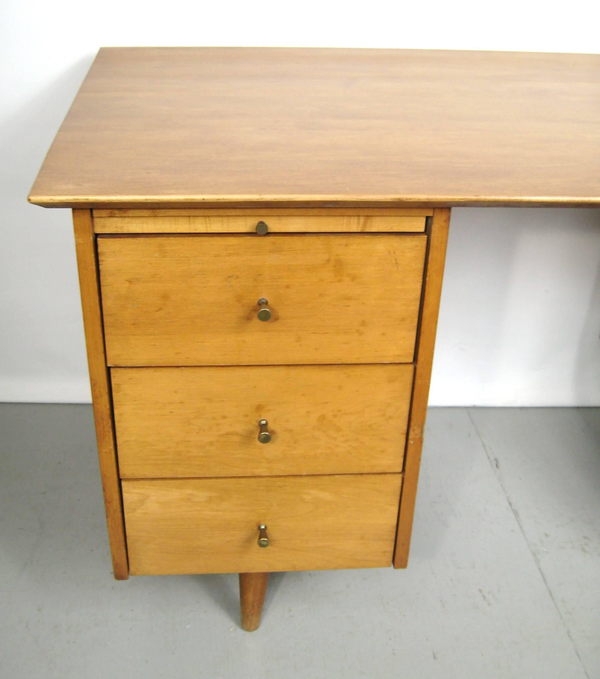 Mid-Century Modern Paul McCobb double pedestal desk with brass hour glass pulls. Five drawers as well as a pullout / pull-out writing tray. Be sure to check our storefront for many more decorating ideas, from primitives, Machine age, Mid-Century