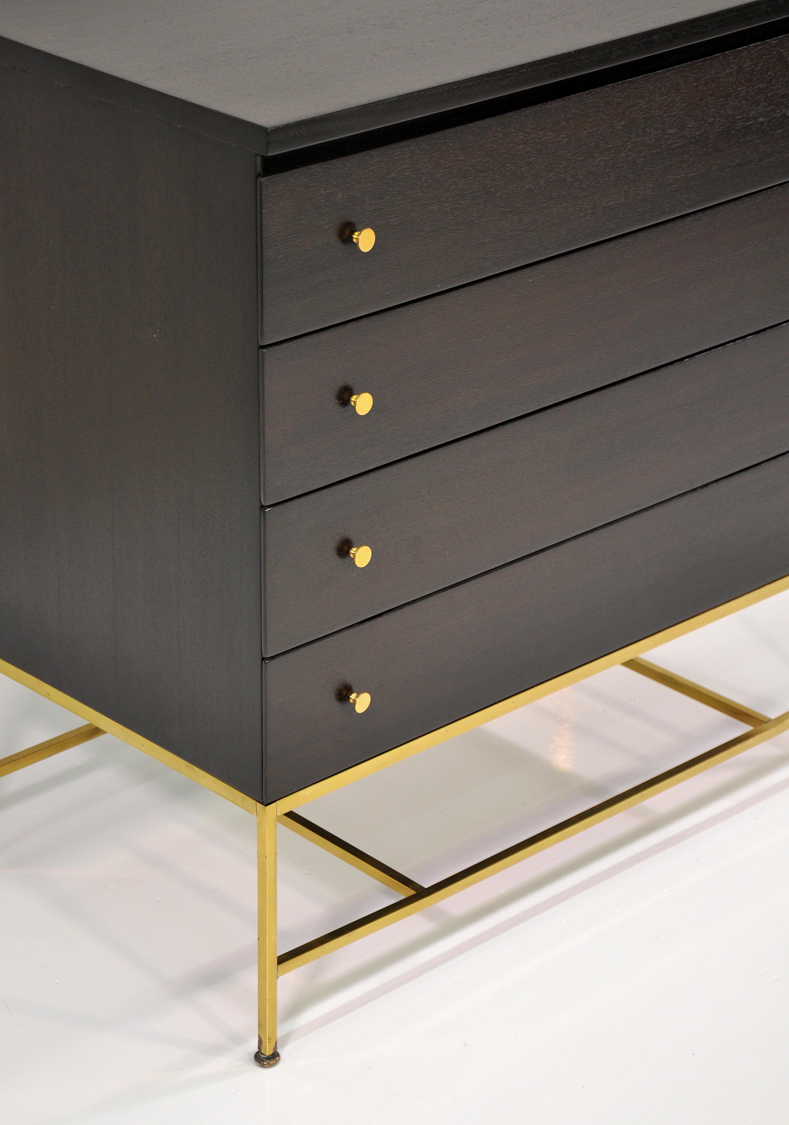 Stunning mahogany and brass chest of drawers from the Irwin Collection designed by Paul McCobb for Directional Furniture; manufactured by Calvin Group, c. 1956. The dresser features an elegant polished brass base and spanners with signature solid