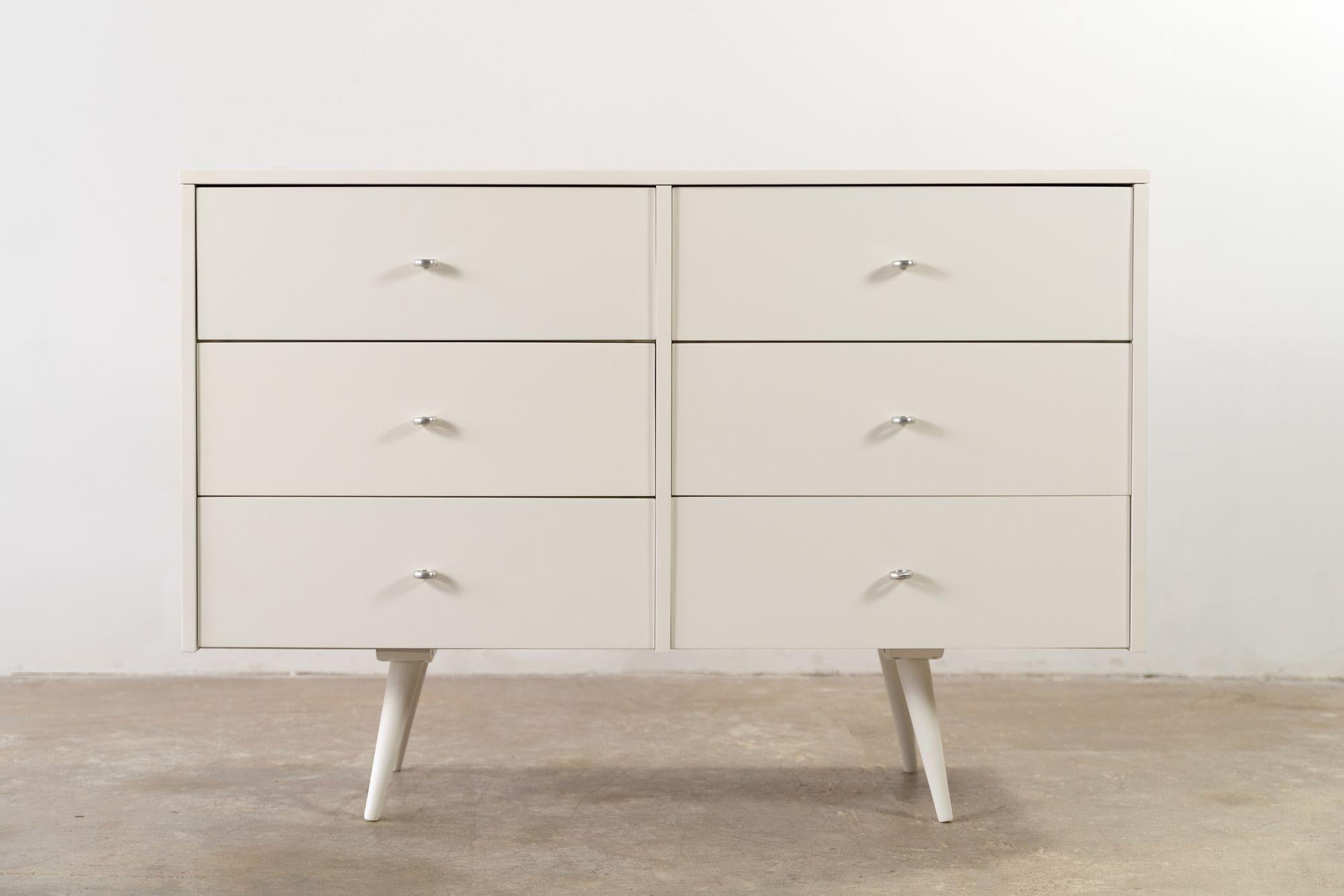 Six-drawer dresser designed by Paul McCobb for the Planner Group Collection and produced by Winchendon in the 1950s. This piece is crafted from solid maple hardwood, is finished in an elegant white lacquer, and retains the original aluminum ring