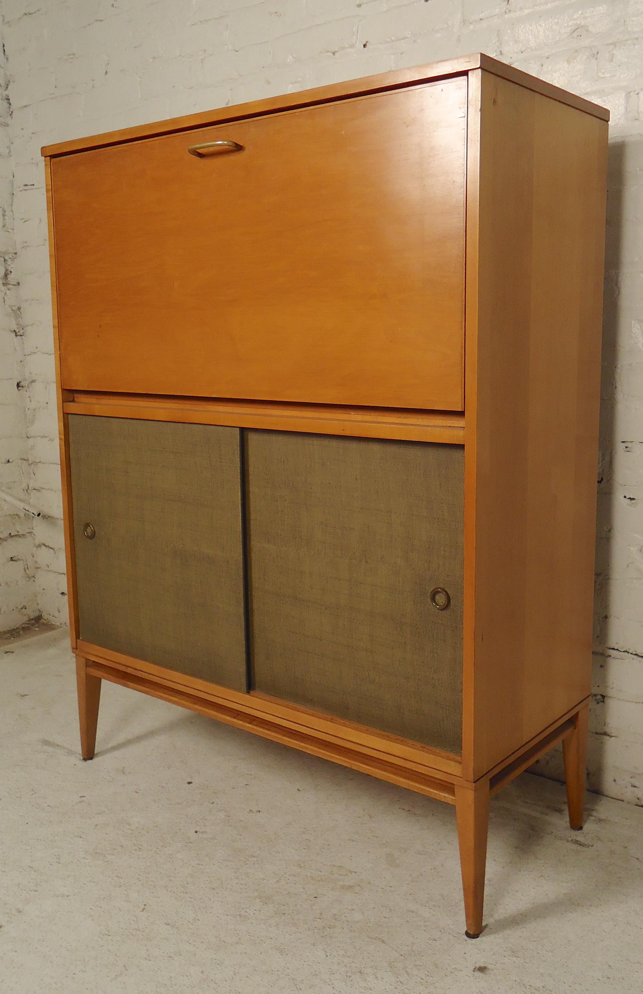 Tall cabinet with drop front storage/desk area. Grass cloth doors, maple wood, tapered legs.
(Please confirm item location - NY or NJ - with dealer).
  