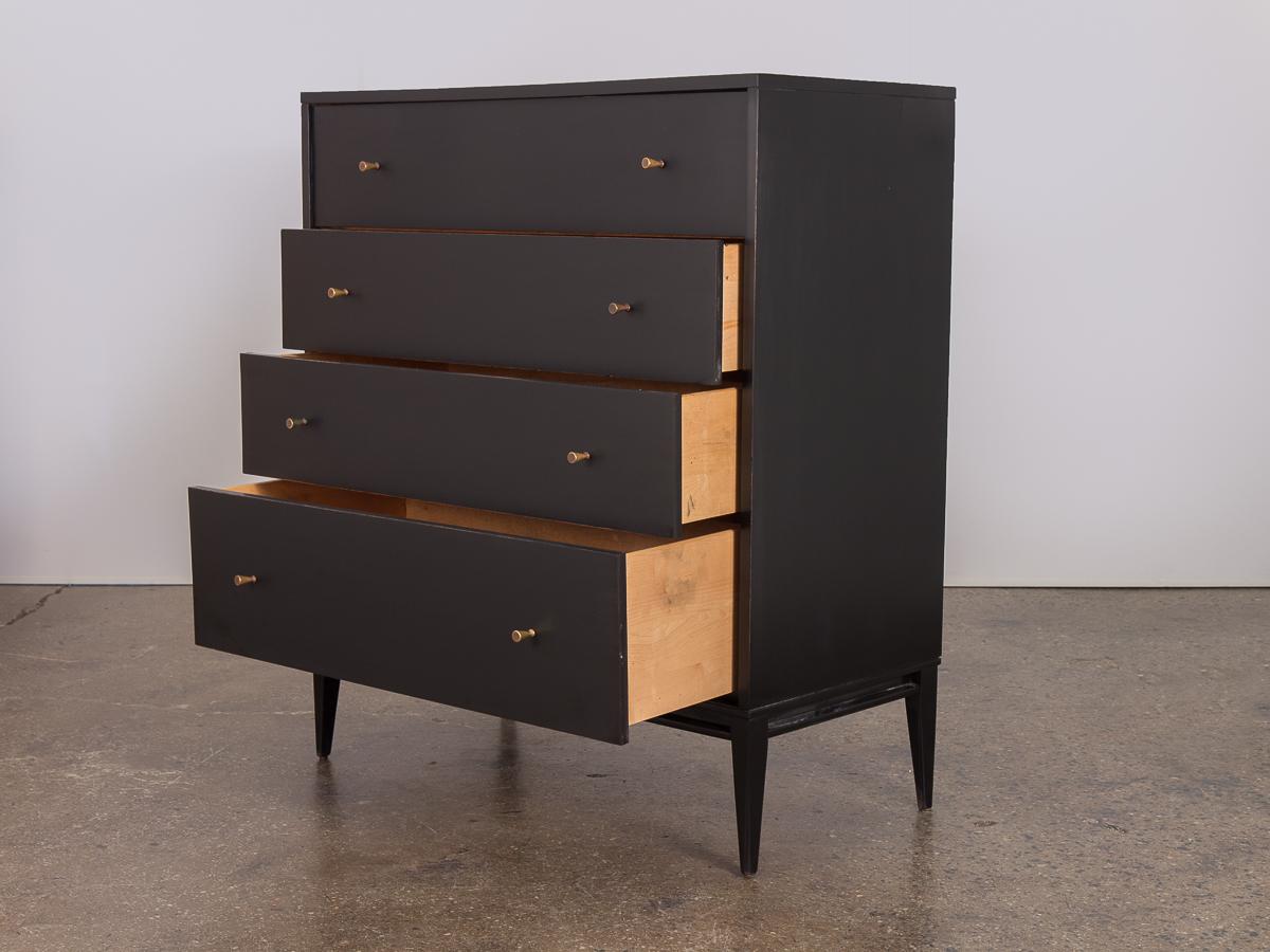 An early 1950s four-drawer ebonized dresser by Paul McCobb for Planner Group. A sensuously classy addition to the bedroom. In excellent condition with the right amount of age. Conical brass knobs own a pretty patina. Subdued ebony finish is clean