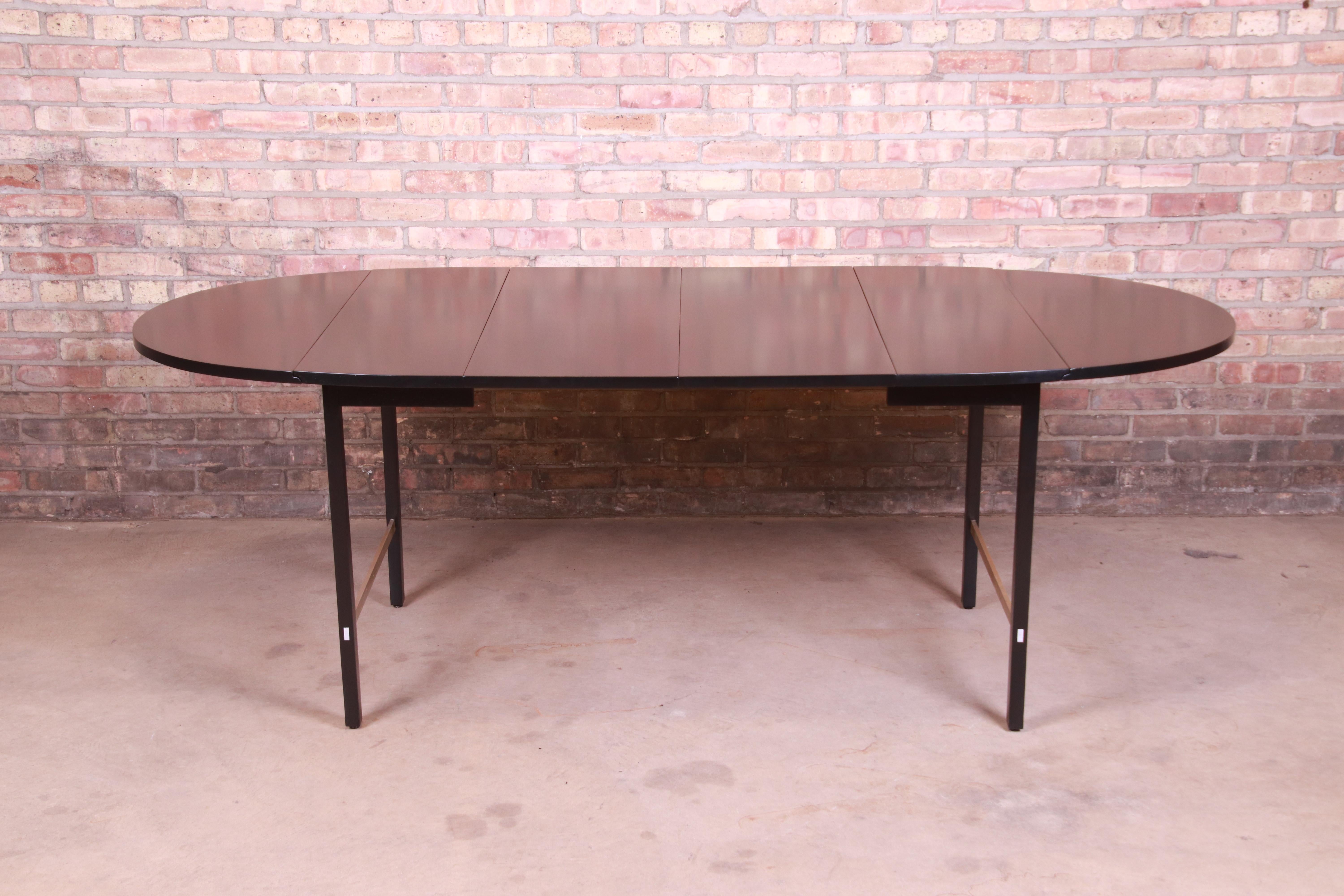 An exceptional Mid-Century Modern drop-leaf extension dining table

By Paul McCobb for Calvin Furniture

USA, circa 1950s

Black lacquered mahogany, with brass stretchers.

Measures: 54