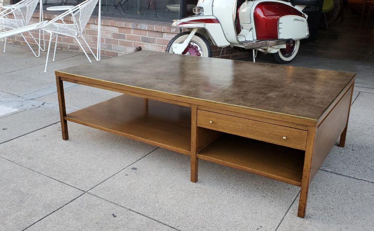 Rare 1950s Paul McCobb leather top coffee table. 
Gorgeous Philippine mahogany, brass trim, tear drop brass pulls, pull out drawer and calvin grand rapids plaque.

Rare vintage leather top coffee table by Paul McCobb for Calvin is made with