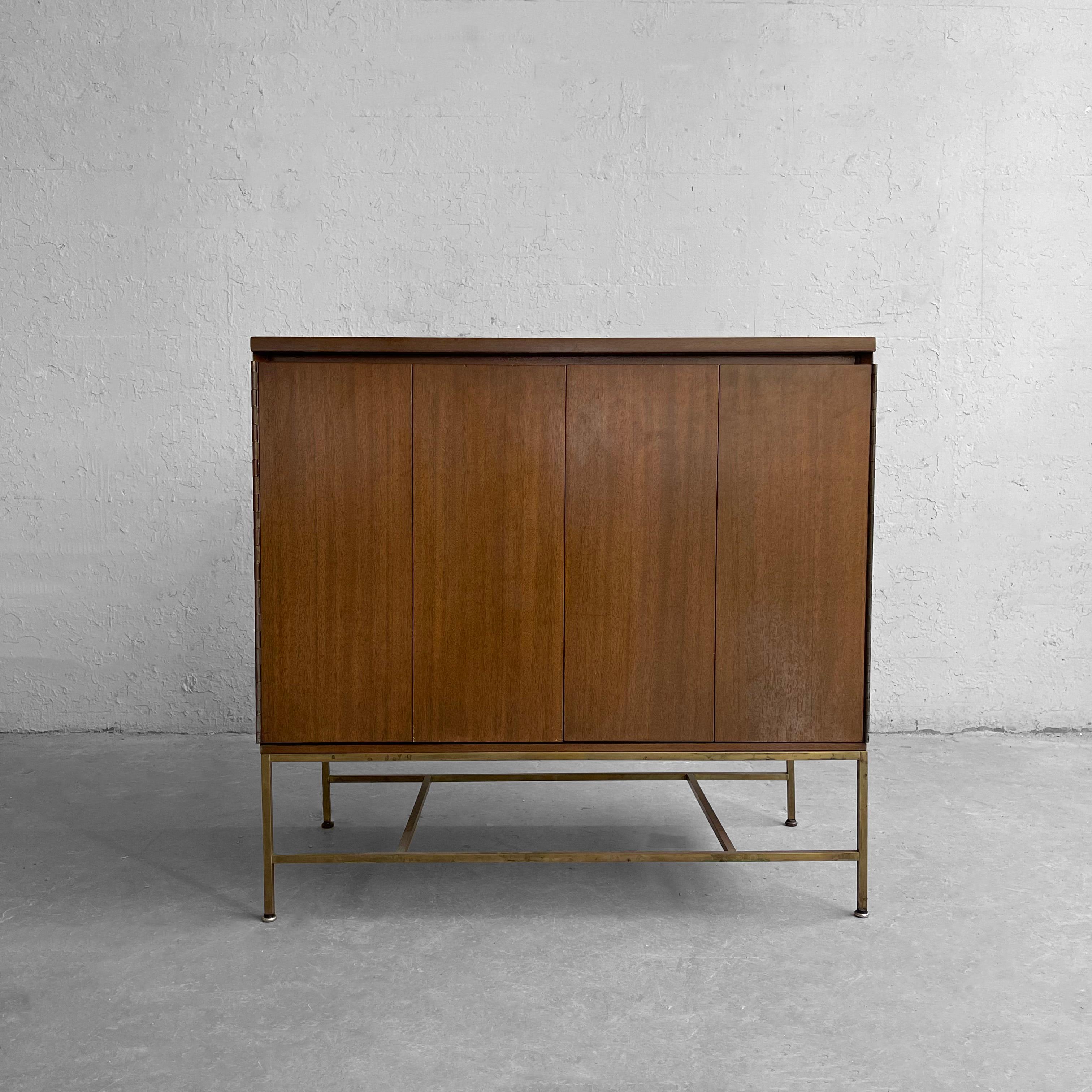 Mid-Century Modern, streamlined, mahogany dresser by Paul McCobb for Calvin Furniture: The Irwin Collection features bi-fold doors that open to reveal four 5 inch height drawers that float on a minimal brass base.