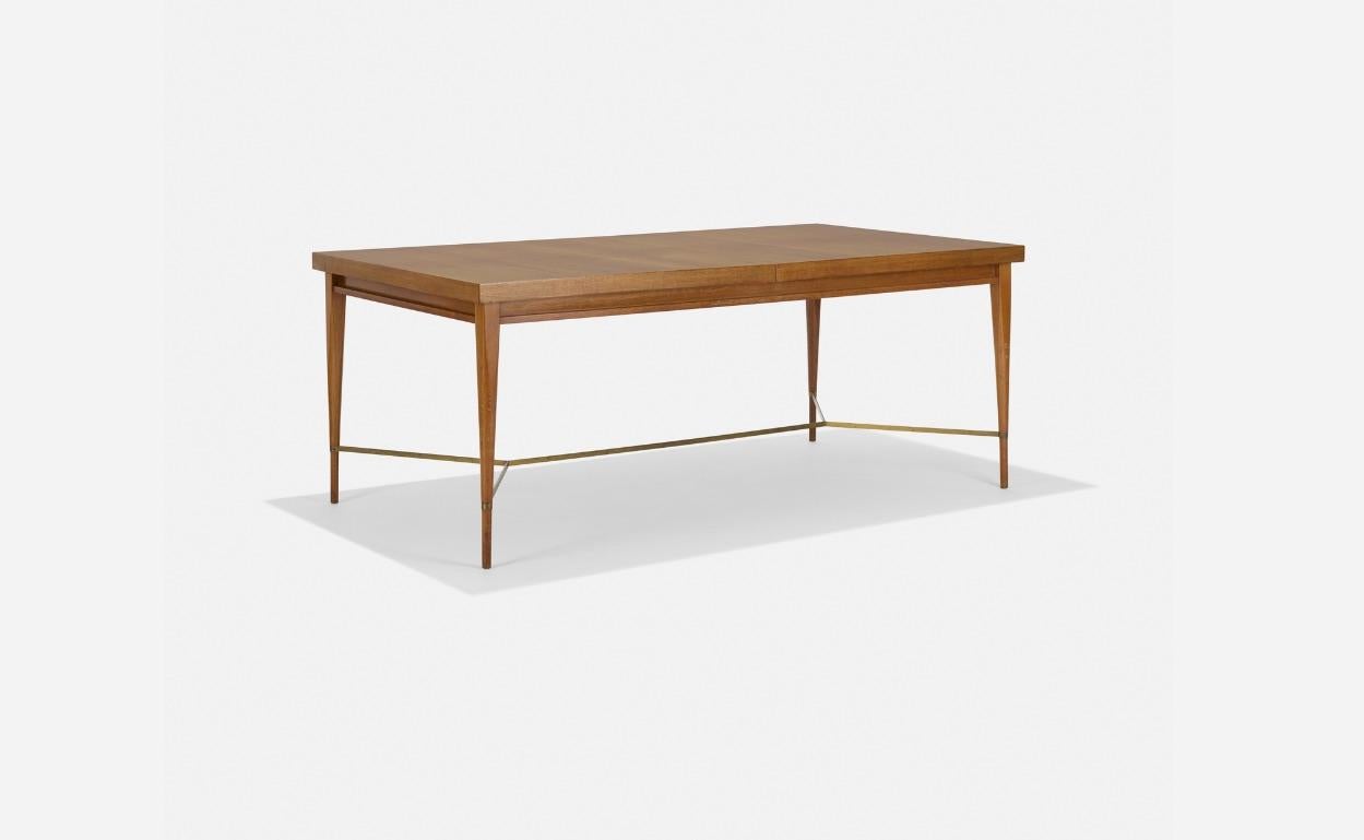 Philippine Mahogany dining table with brass X stretcher between tapered legs, designed by Paul McCobb, part of his Irwin collection for Calvin. Includes two 15