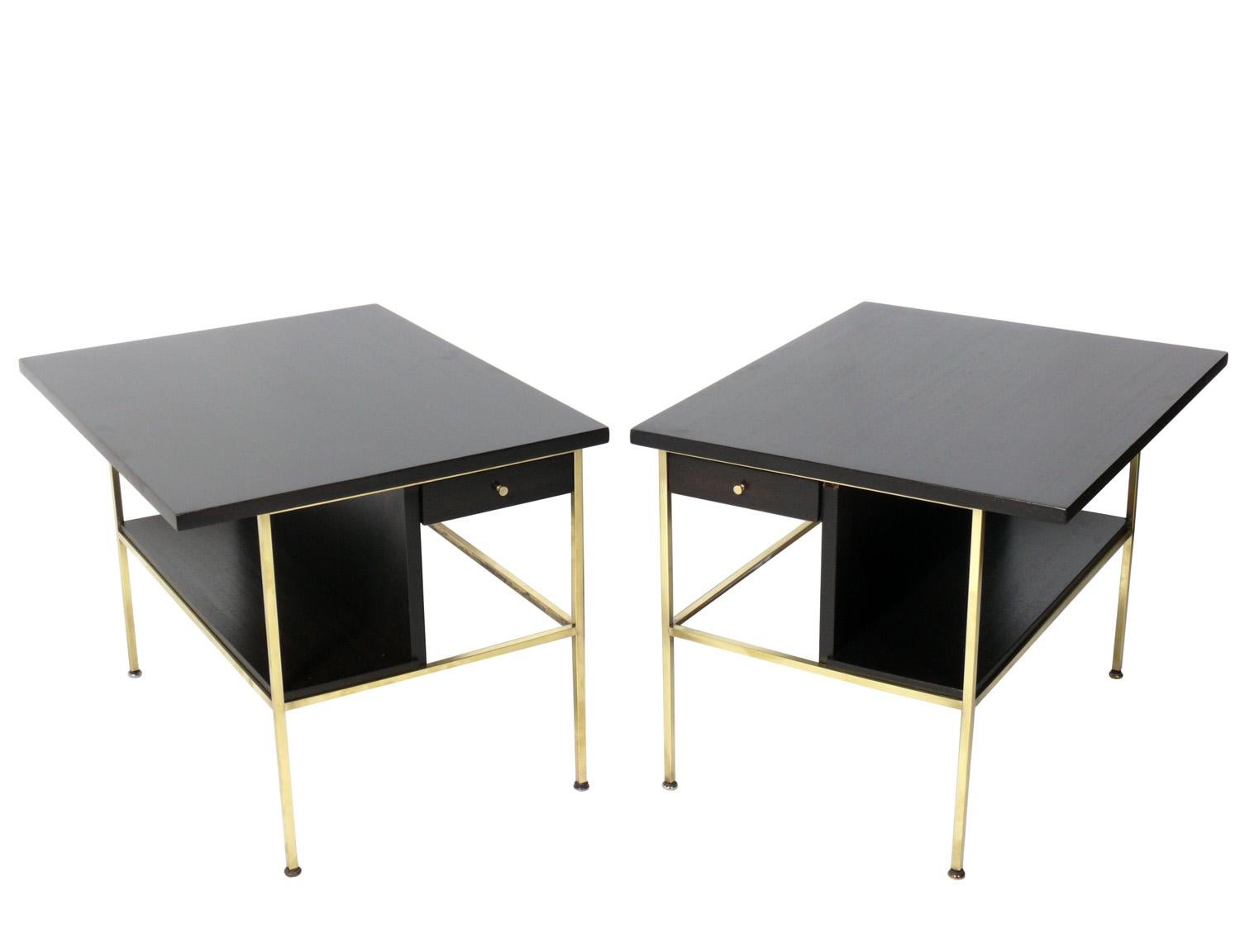 Mid-Century Modern side tables or nightstands, designed by Paul McCobb for Calvin, American, circa 1950s. Signed inside drawer. They have been completely restored in a deep brown color finish and the brass portions have been polished and lacquered.