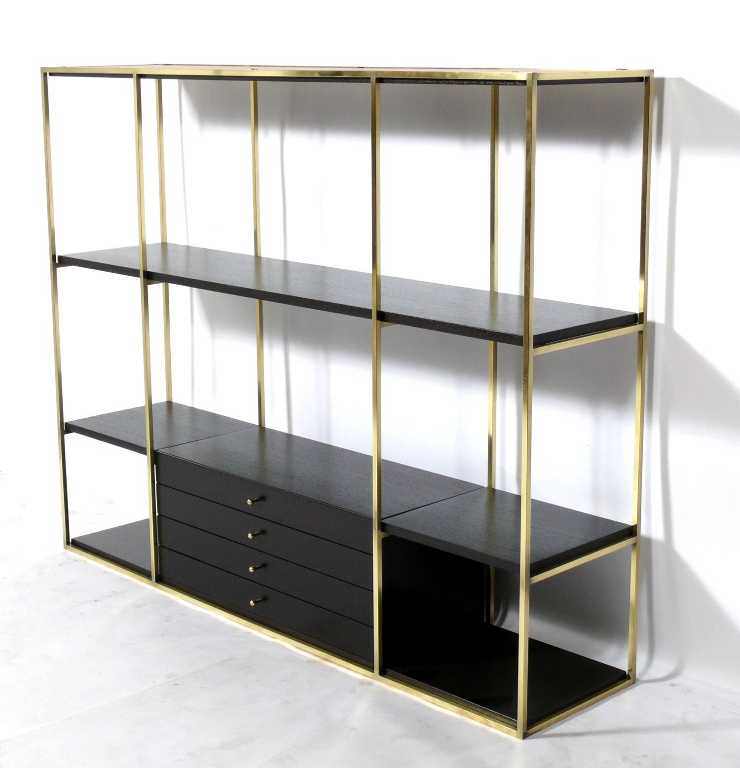 Mid-Century Modern étagère or bookshelf, designed by Paul McCobb for Calvin, American, circa 1950s. Signed inside drawer. It has been completely restored in a deep brown color finish and the brass portions have been polished and lacquered.