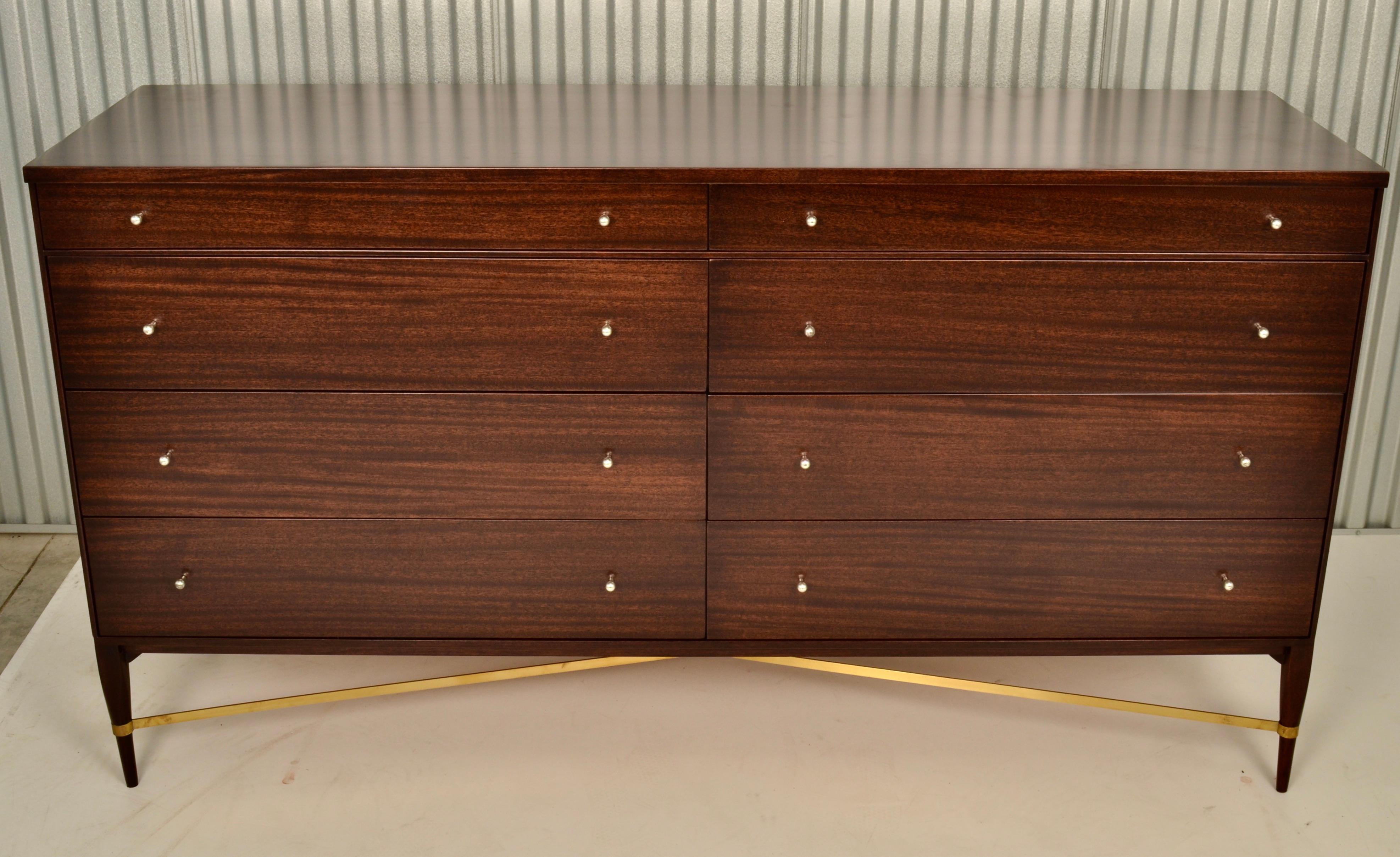Featuring signature brass cross stretcher, this McCobb chest has been fully restored in a rich dark walnut stain with satin finish. Designed for Calvin Group circa 1950s. Original hardware. Very fine condition.