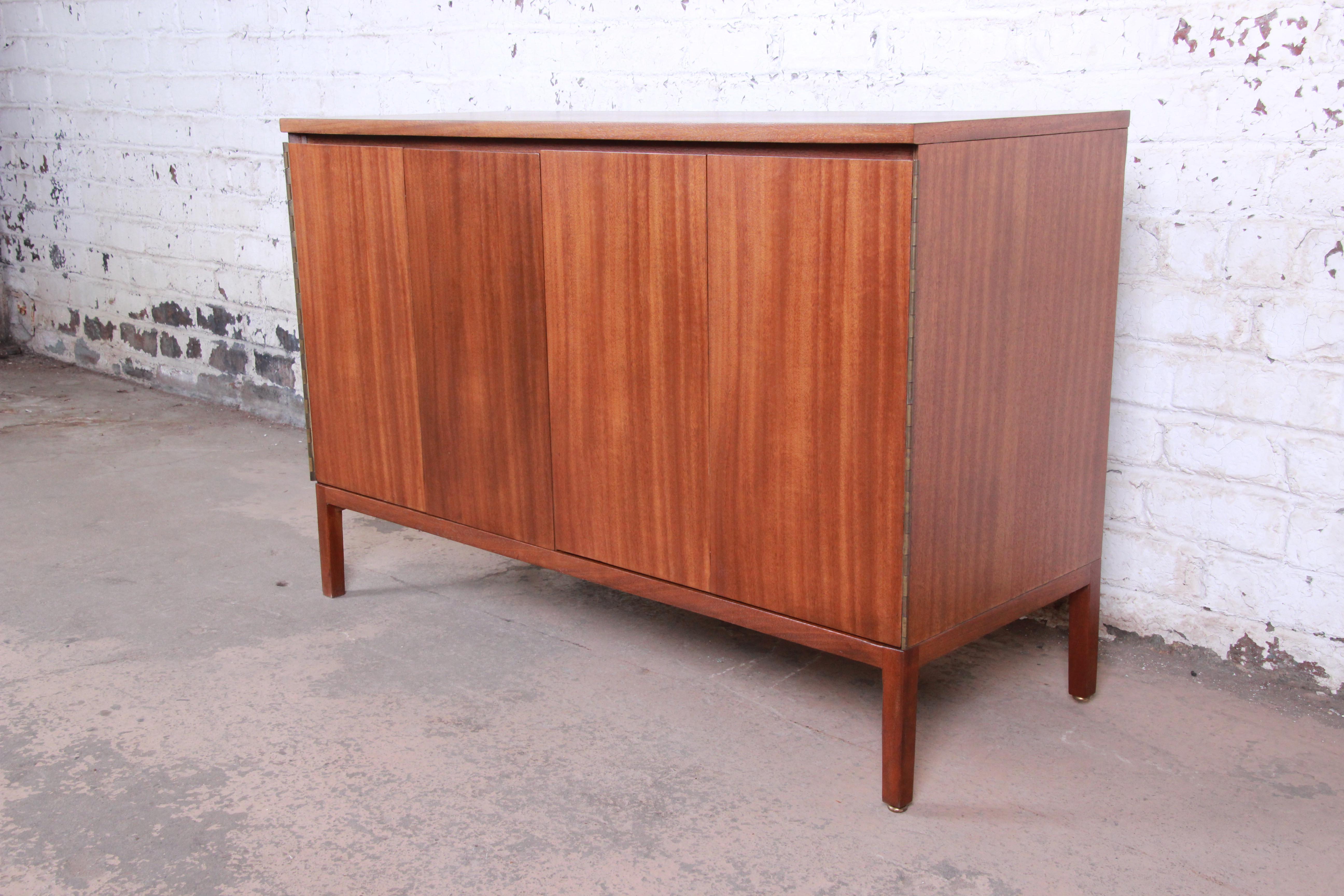 An exceptional Mid-Century Modern sideboard or bar cabinet designed by Paul McCobb for his Irwin Collection line for Calvin Furniture. The cabinet features stunning Honduran mahogany wood grain and sleek mid-century lines. An excellent example of