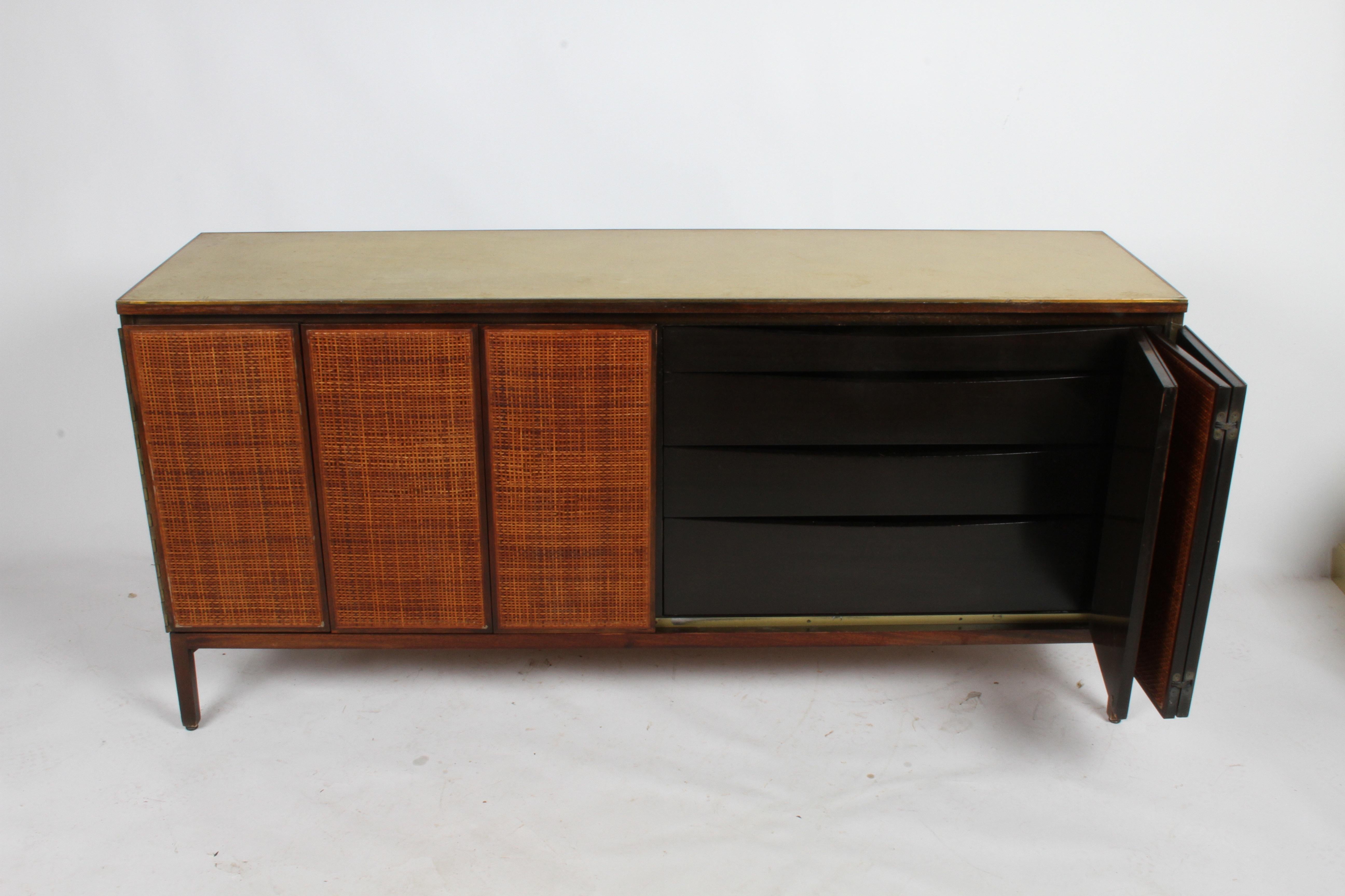 To be restored, Paul McCobb for Calvin Group dresser, sideboard or credenza with original leather top, brass edge and caned front panels. Shown in original condition, front panels to be restored and refinished, mahogany sides, legs and edges to be