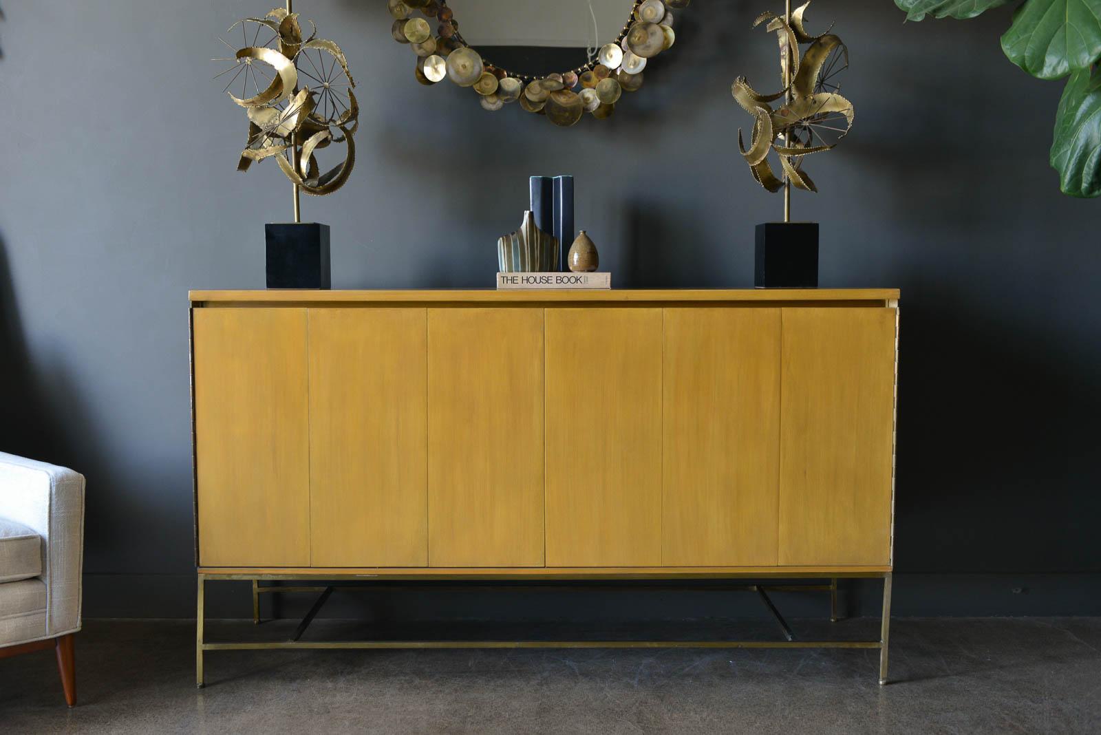 Paul McCobb for Calvin Mahogany and brass credenza, ca. 1955. Original bleached mahogany with brass base features tri-fold accordion doors. Outside of credenza has been refinished, base has been slightly polished. Retains the original feet as well