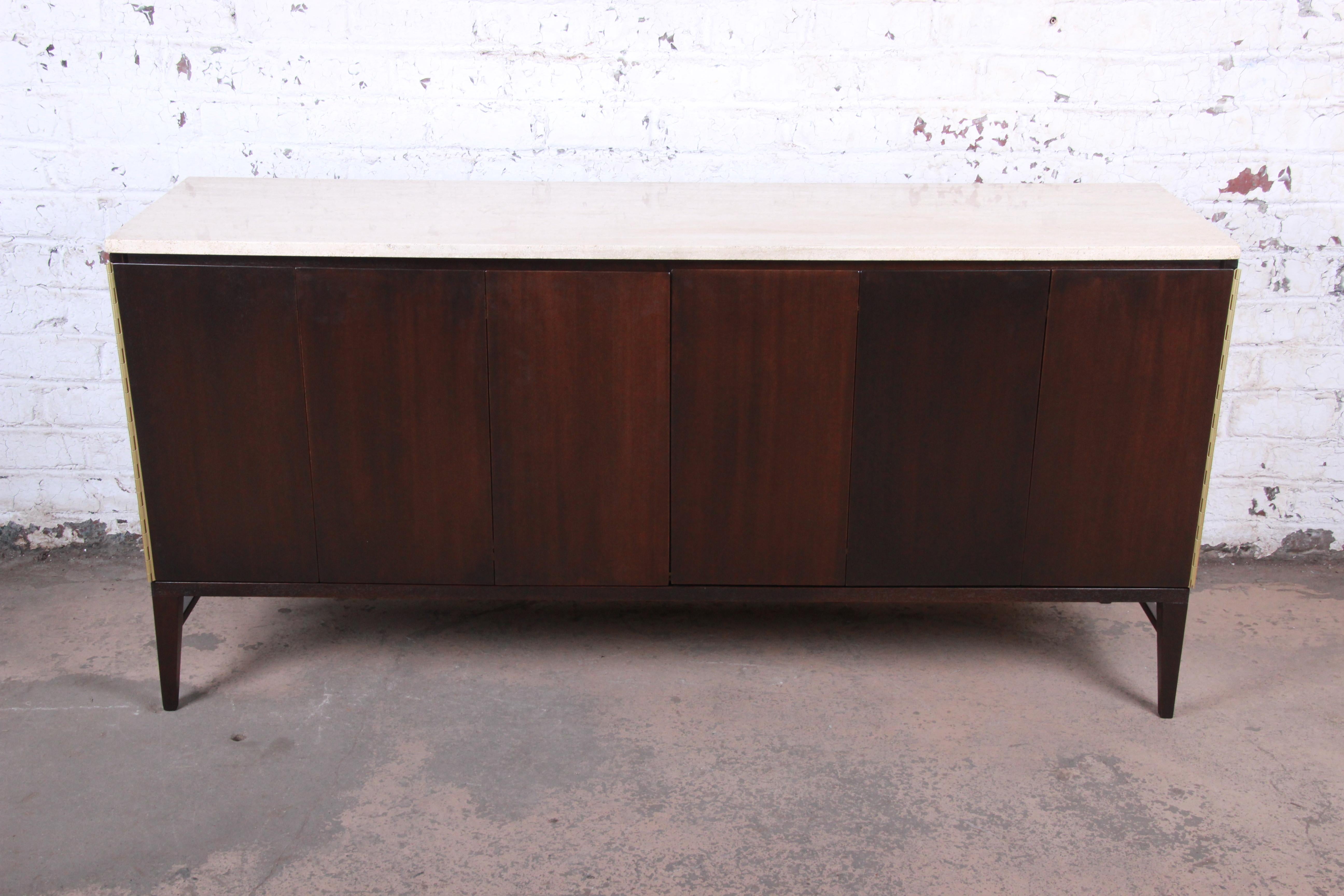 A stunning Mid-Century Modern Minimalist credenza or long dresser

By Paul McCobb for Calvin Furniture

USA, 1950s

Mahogany + travertine + brass. Ten drawers behind two tri-fold doors. Back is finished.

Measures: 71.13