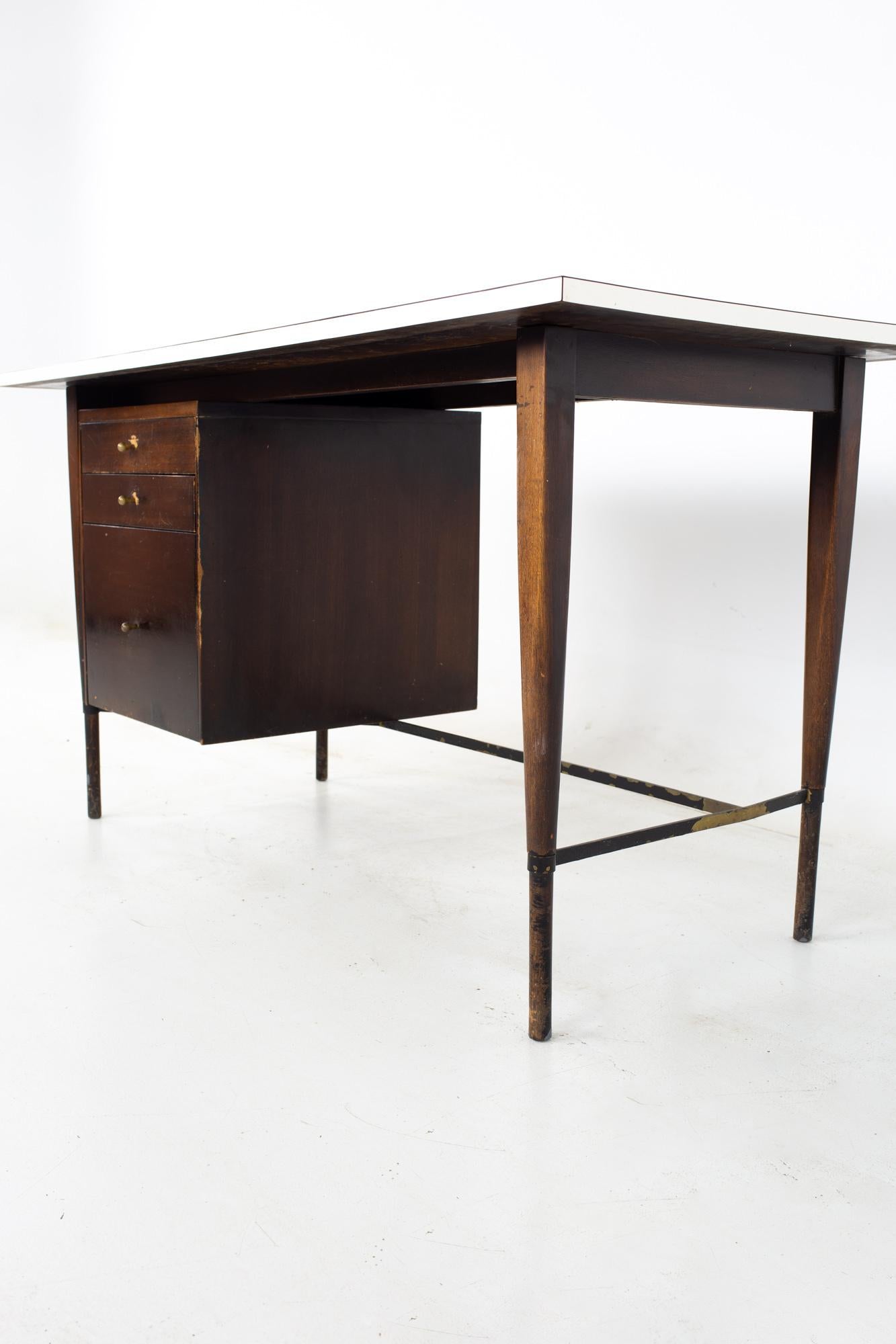 Paul McCobb for Calvin mid century ebonized mahogany brass and white laminate desk
Desk measures: 54.5 wide x 26 deep x 29 inches high, with a chair clearance of 26.5 inches 

All pieces of furniture can be had in what we call restored vintage
