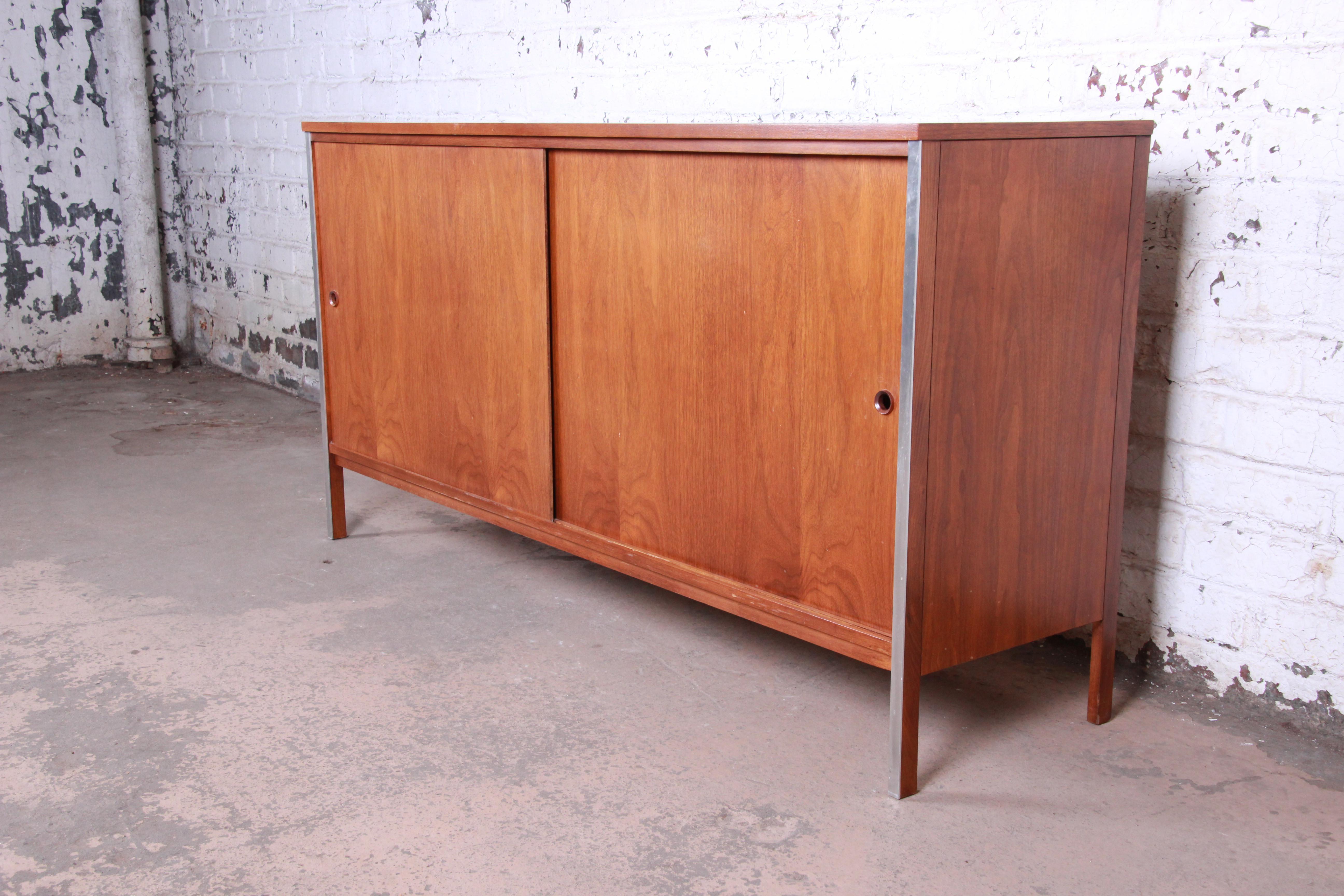 An exceptional Mid-Century Modern walnut sideboard or credenza designed by Paul McCobb for his Linear Group line for Calvin Furniture. The credenza features gorgeous walnut wood grain with aluminum trim. It offers good storage, with two dovetailed