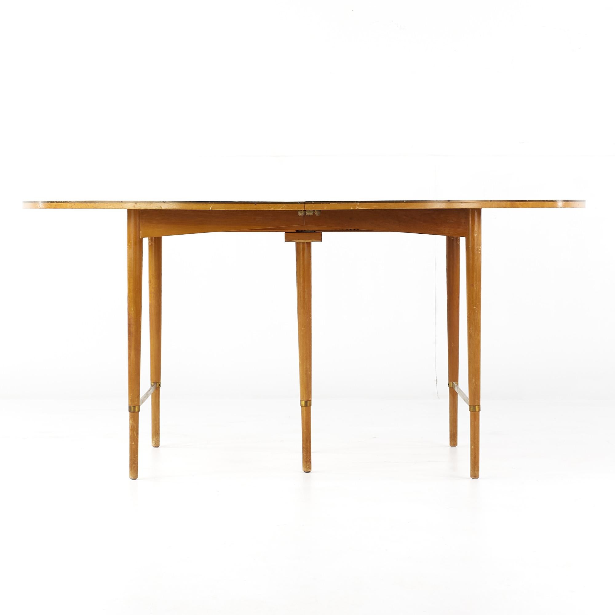 Paul McCobb for Calvin mid century walnut and brass dining table with 6 leaves

This table measures: 62.25 wide x 41.25 deep x 29 high, with a chair clearance of 28 inches, each leaf measures 11 inches wide, making a maximum table width of 128.25