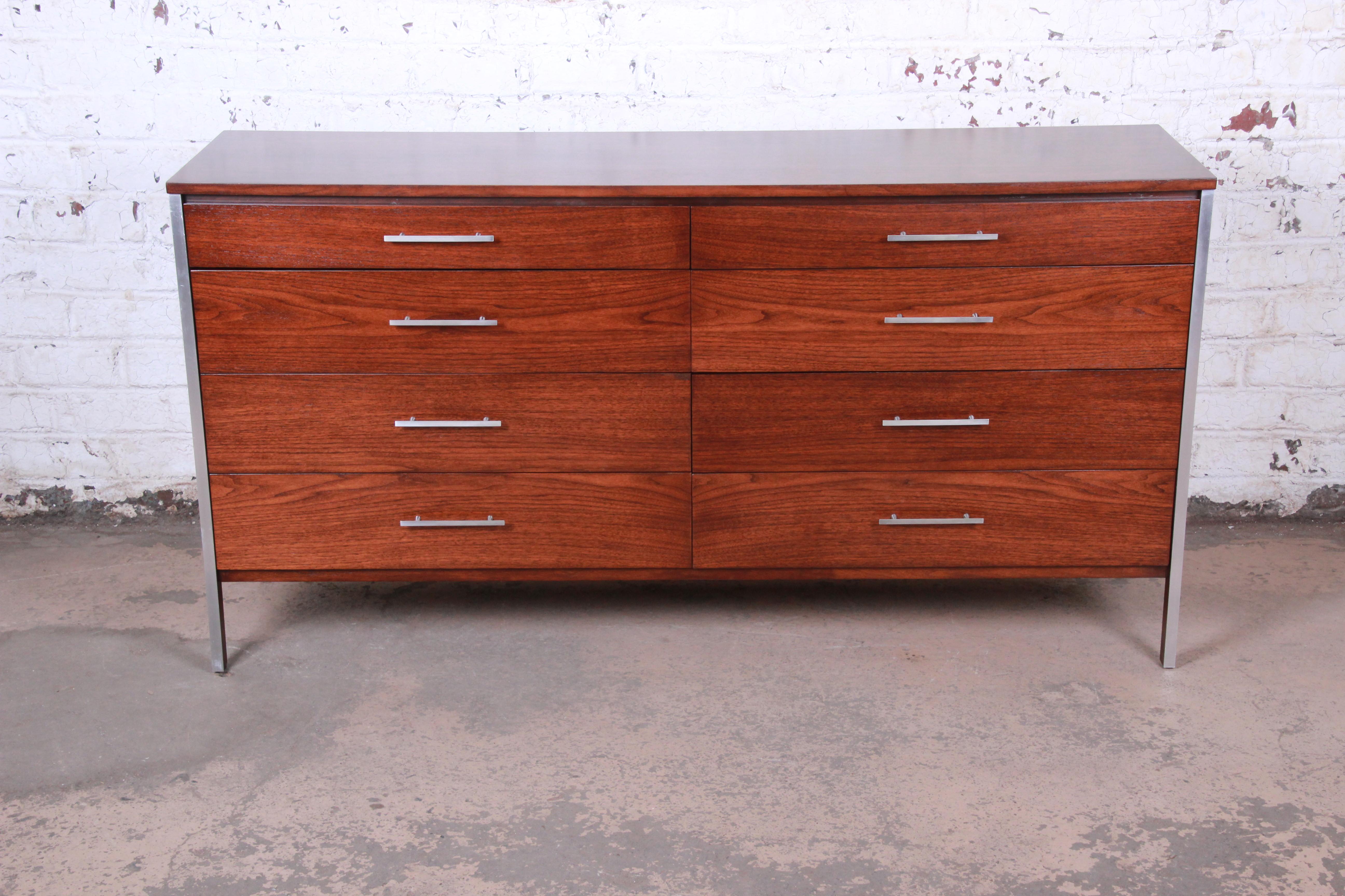 An exceptional Mid-Century Modern long dresser or credenza designed by Paul McCobb for Calvin Furniture. The dresser features gorgeous walnut wood grain with aluminum trim and hardware. It offers ample storage, with eight deep dovetailed drawers. An