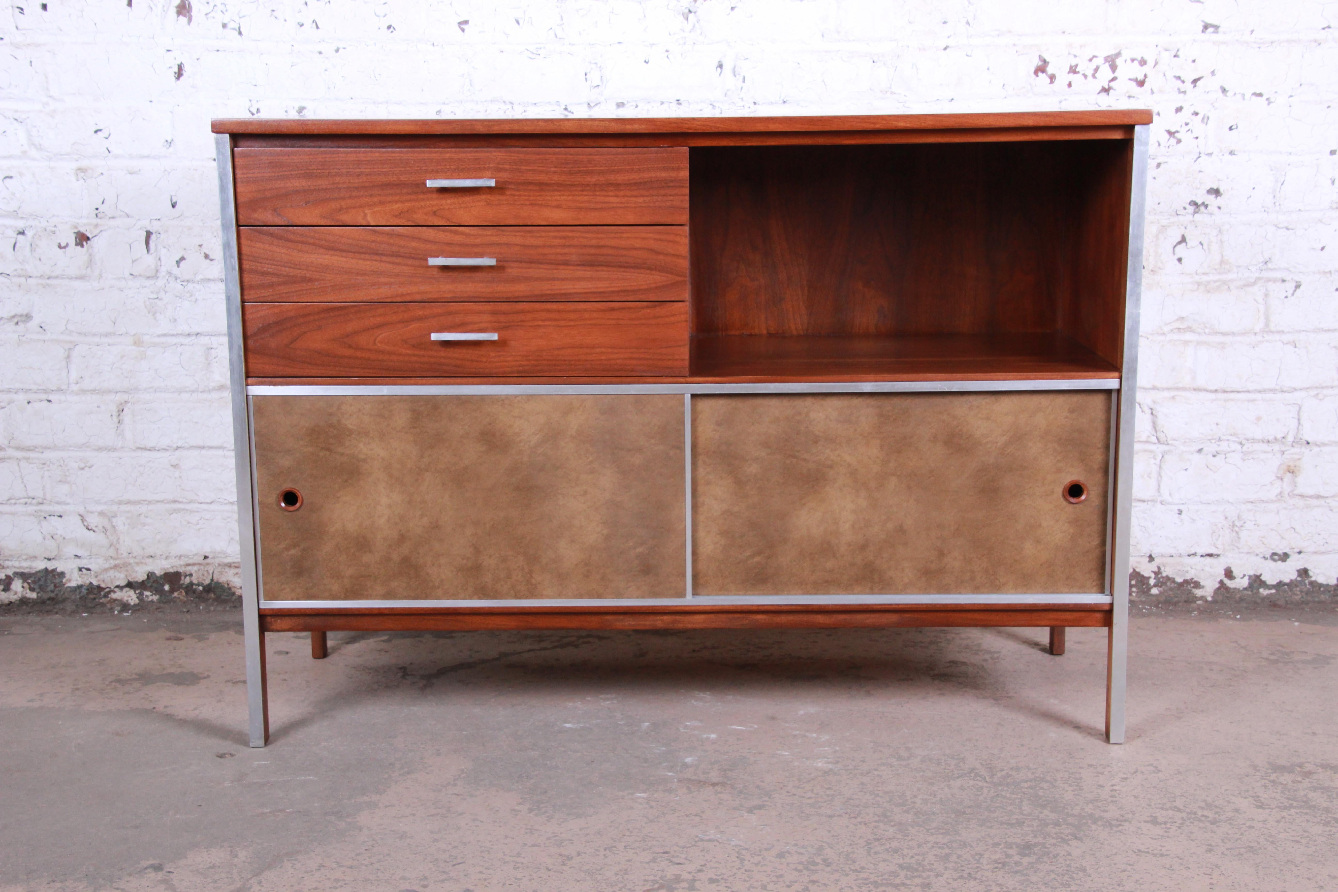 An exceptional Mid-Century Modern credenza or media cabinet designed by Paul McCobb for his Linear Group line for Calvin Furniture. The credenza features stunning walnut wood grain with aluminum trim and hardware. It offers great storage, with three