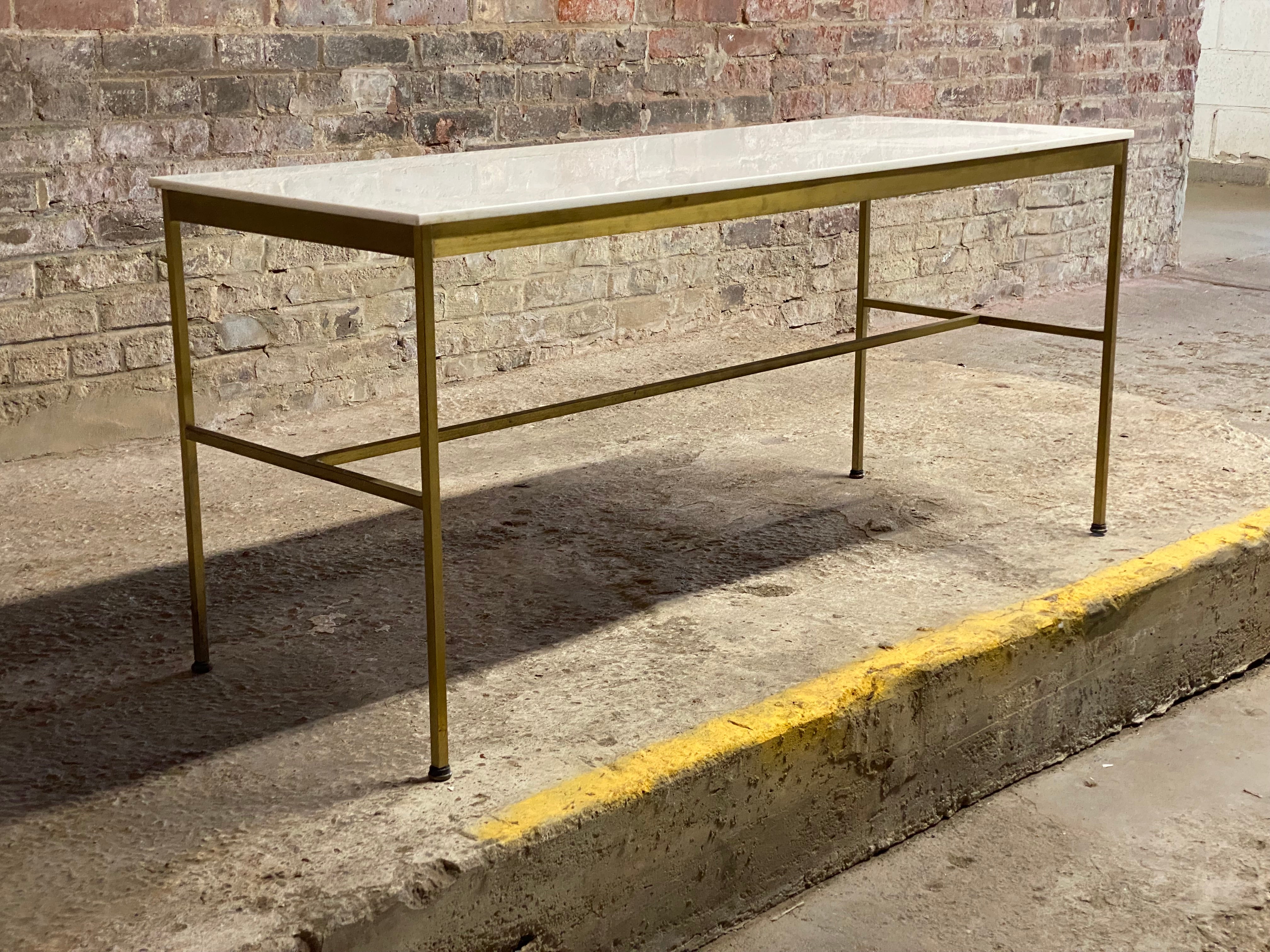 Paul McCobb for Calvin white vitrolite glass top with angular brass base console table. Circa 1955-58. McCobb's Calvin creations were some of the most sophisticated and desirable pieces he designed. The condition of the base is good with some minor