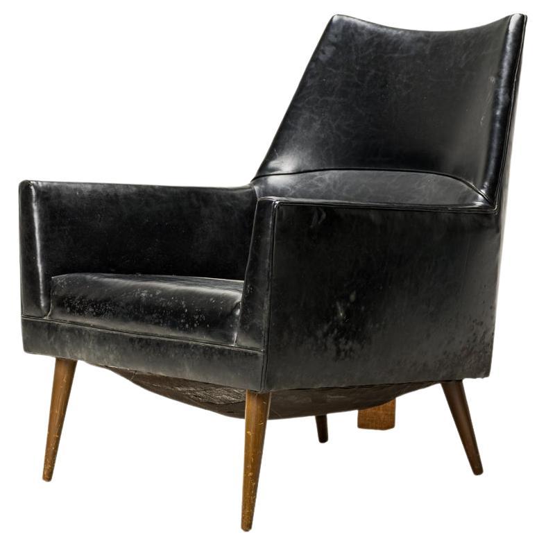 Amerikanischer Loungesessel / Sessel aus der Mitte des Jahrhunderts mit spitz zulaufender Rückenlehne, quadratischem Profil und schwarzem Lederbezug, der auf vier spitz zulaufenden Beinen aus Walnussholz ruht. (PAUL MCCOBB FOR CUSTOM CRAFT