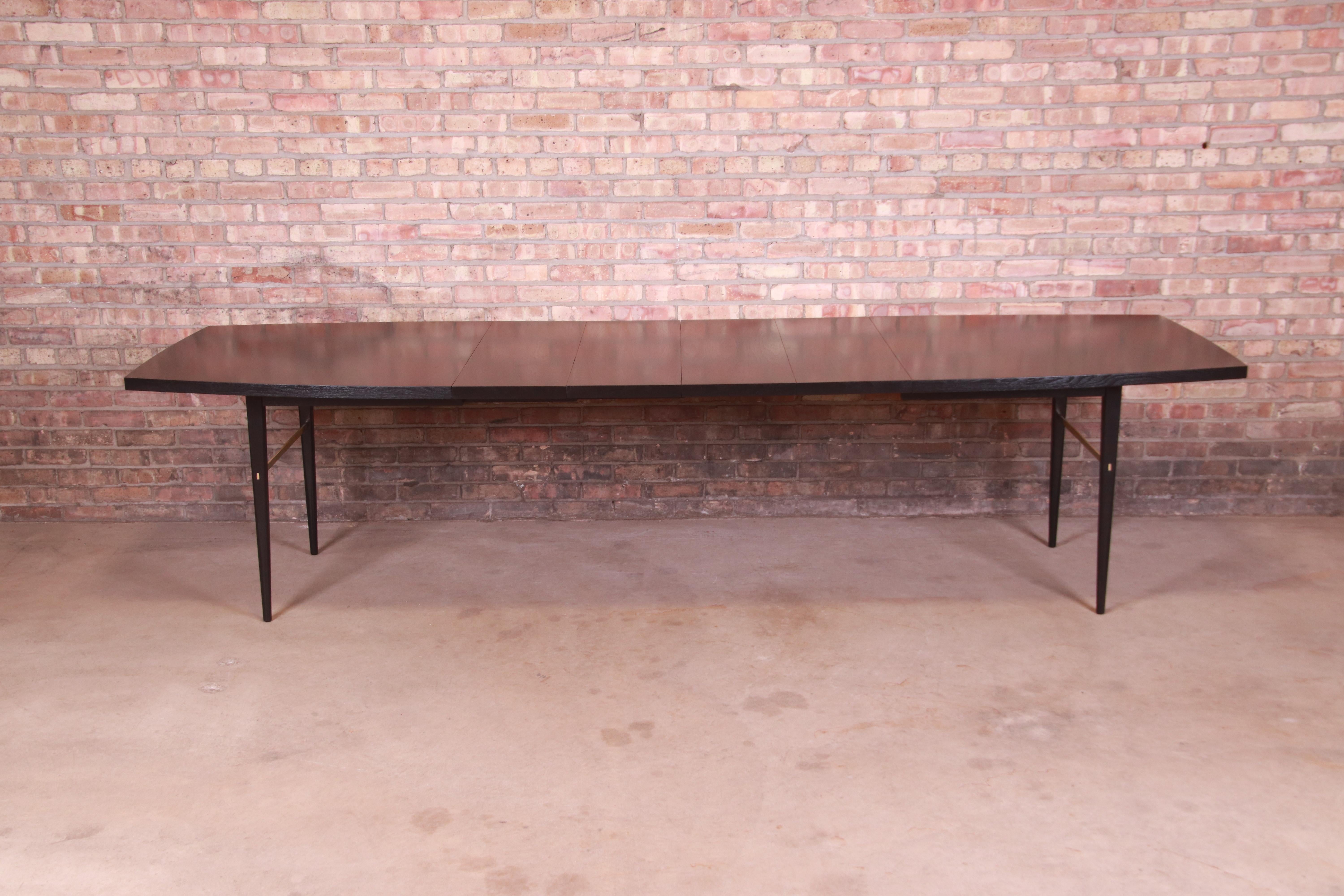 An exceptional Mid-Century Modern extension dining table

By Paul McCobb for Directional and produced by Calvin Furniture

USA, 1950s

Black lacquered walnut, with brass stretchers.

Measures: 72