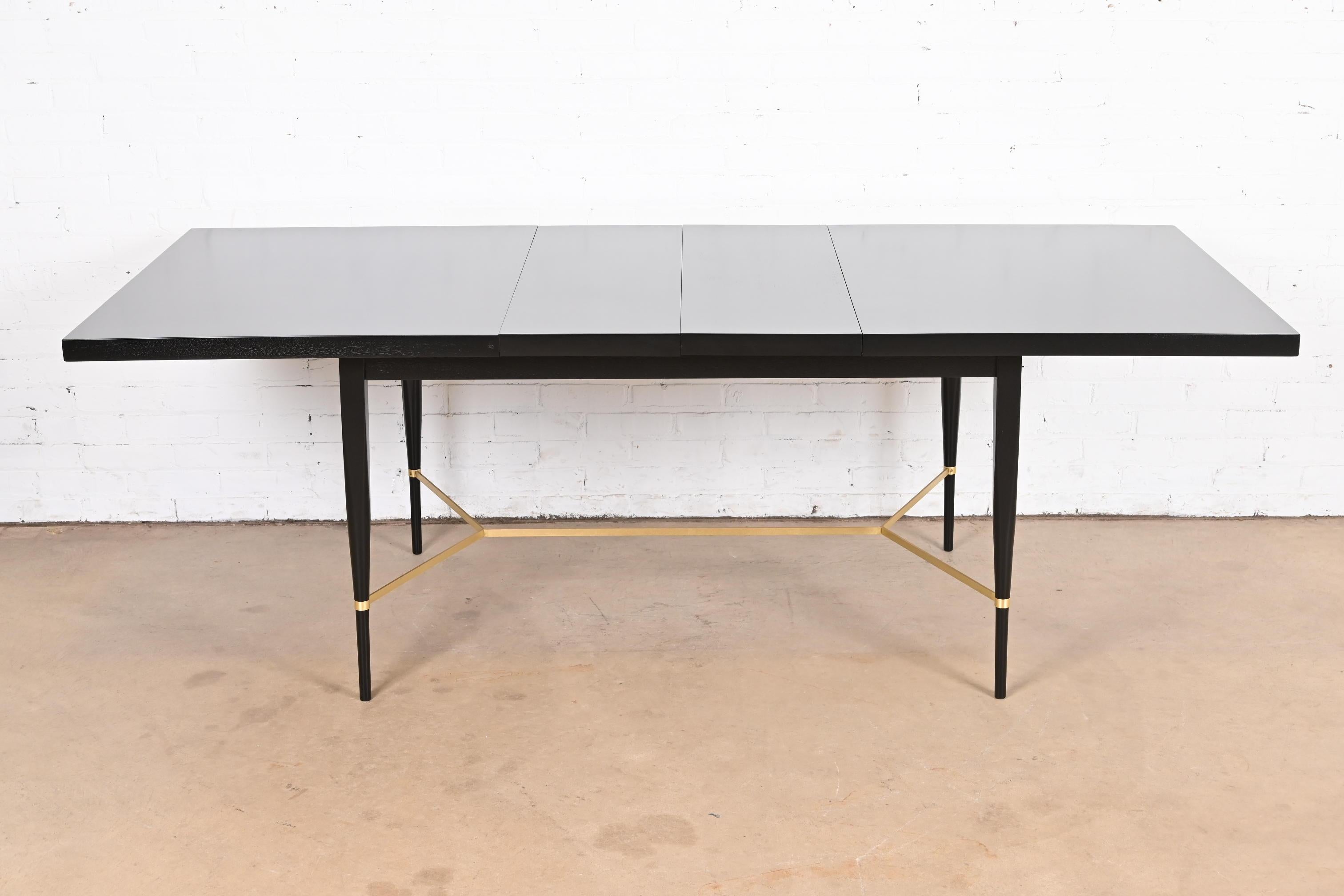 An exceptional Mid-Century Modern extension dining table

By Paul McCobb for Directional and produced by Calvin Furniture

USA, 1950s

Black lacquered mahogany, with brass stretchers.

Measures: 60