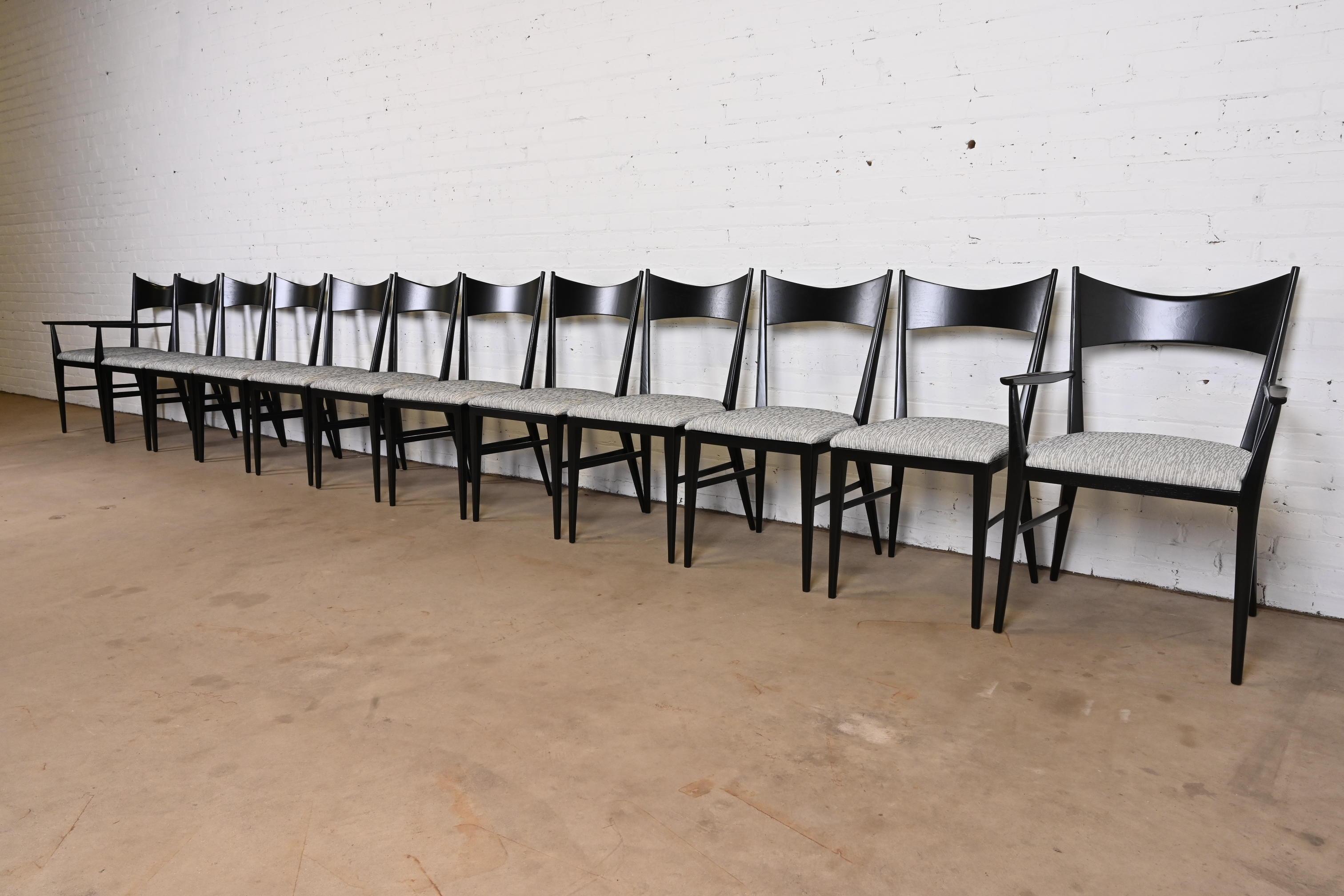 An exceptional set of twelve Mid-Century Modern bow tie dining chairs.

By Paul McCobb for Directional and produced by Calvin Furniture.

USA, 1950s.

Elegant sculpted black lacquered walnut frames with with upholstered