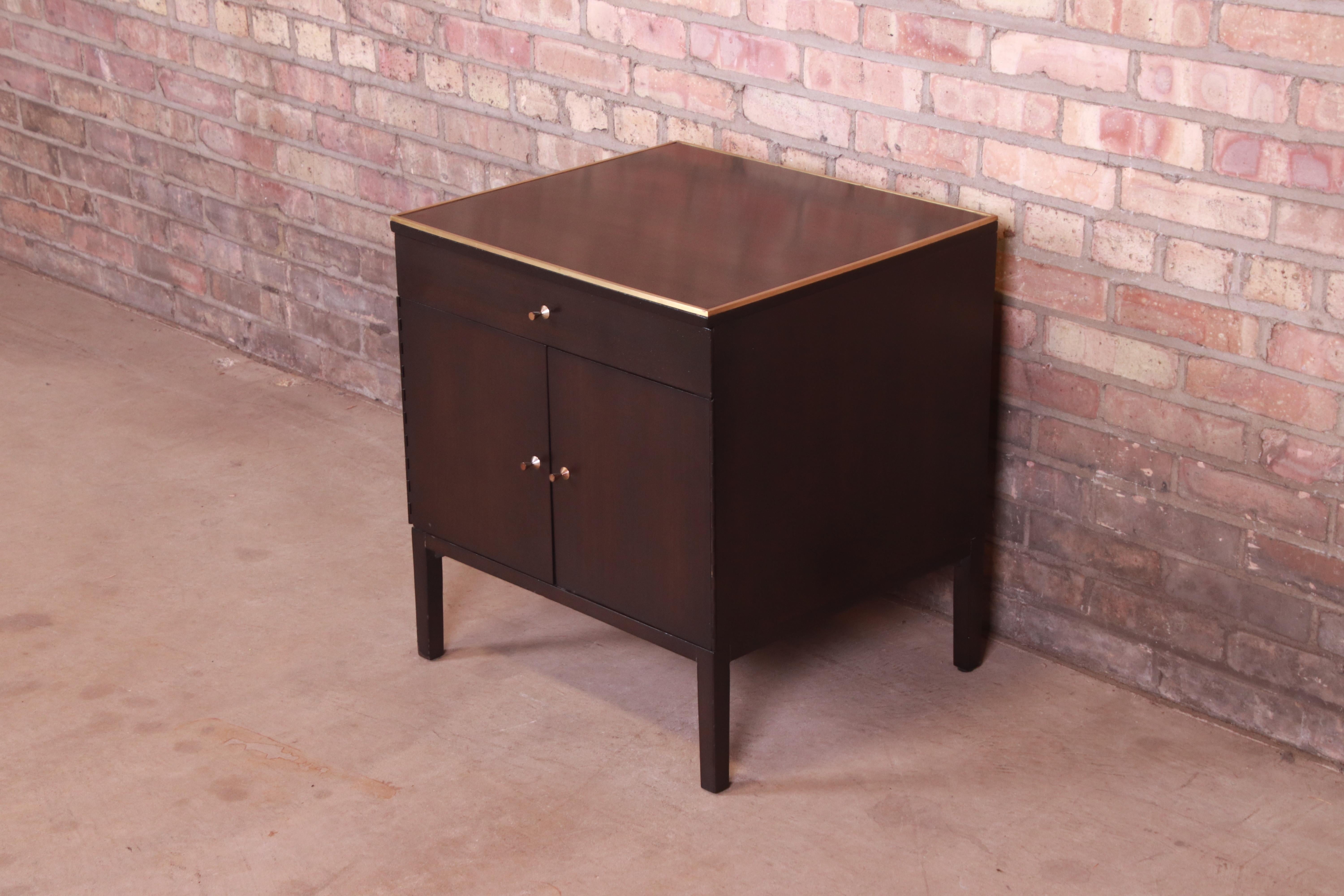 A gorgeous Mid-Century Modern bedside table or end table

By Paul McCobb for Directional and produced by Calvin Furniture

USA, 1950s

Ebonized mahogany, with inlaid brass trim.

Measures: 22