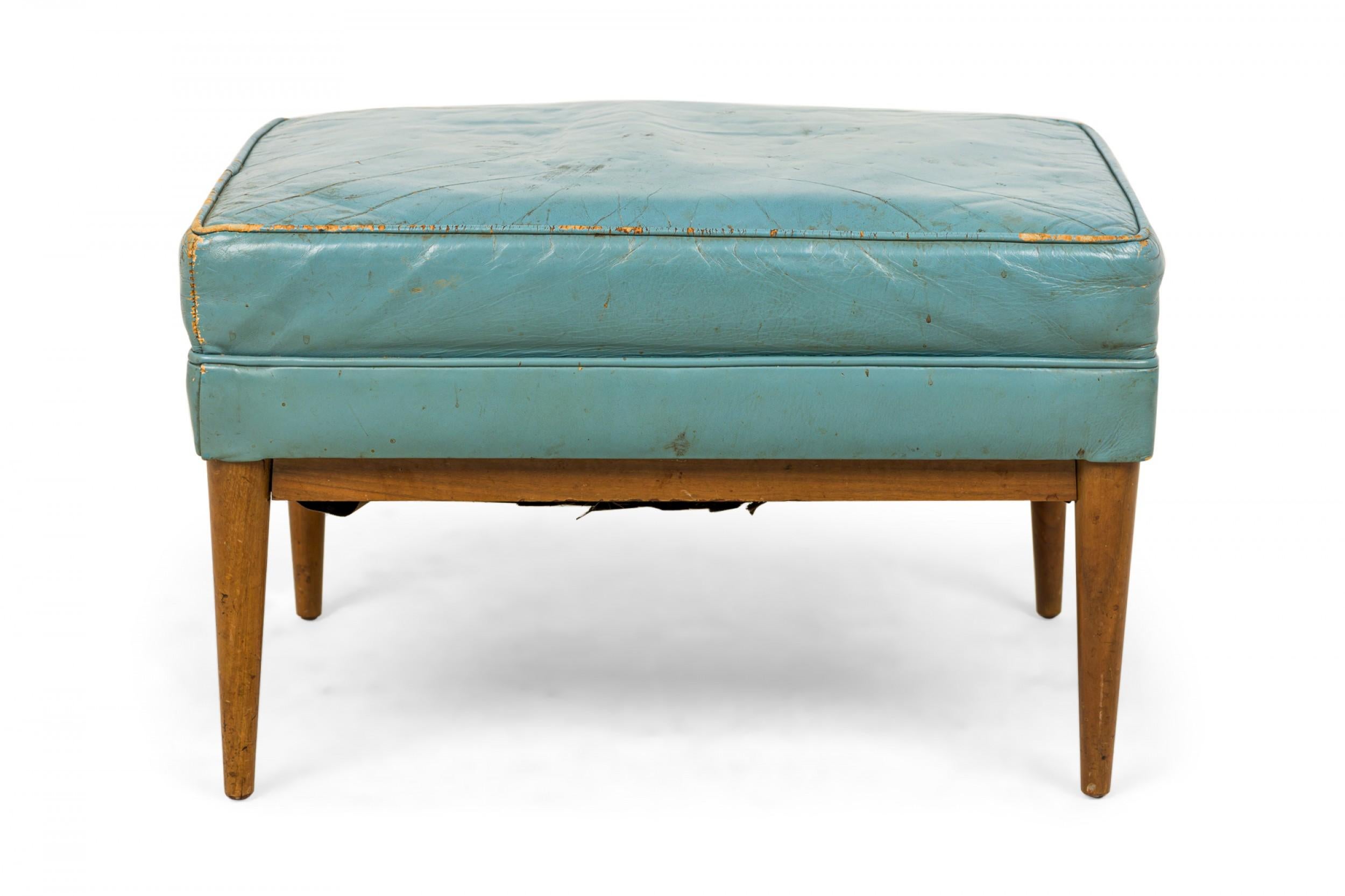 American Mid-Century rectangular ottoman with a blue leather upholstered seat resting on a walnut frame with tapered legs. (Paul Mccobb for Directional).
     