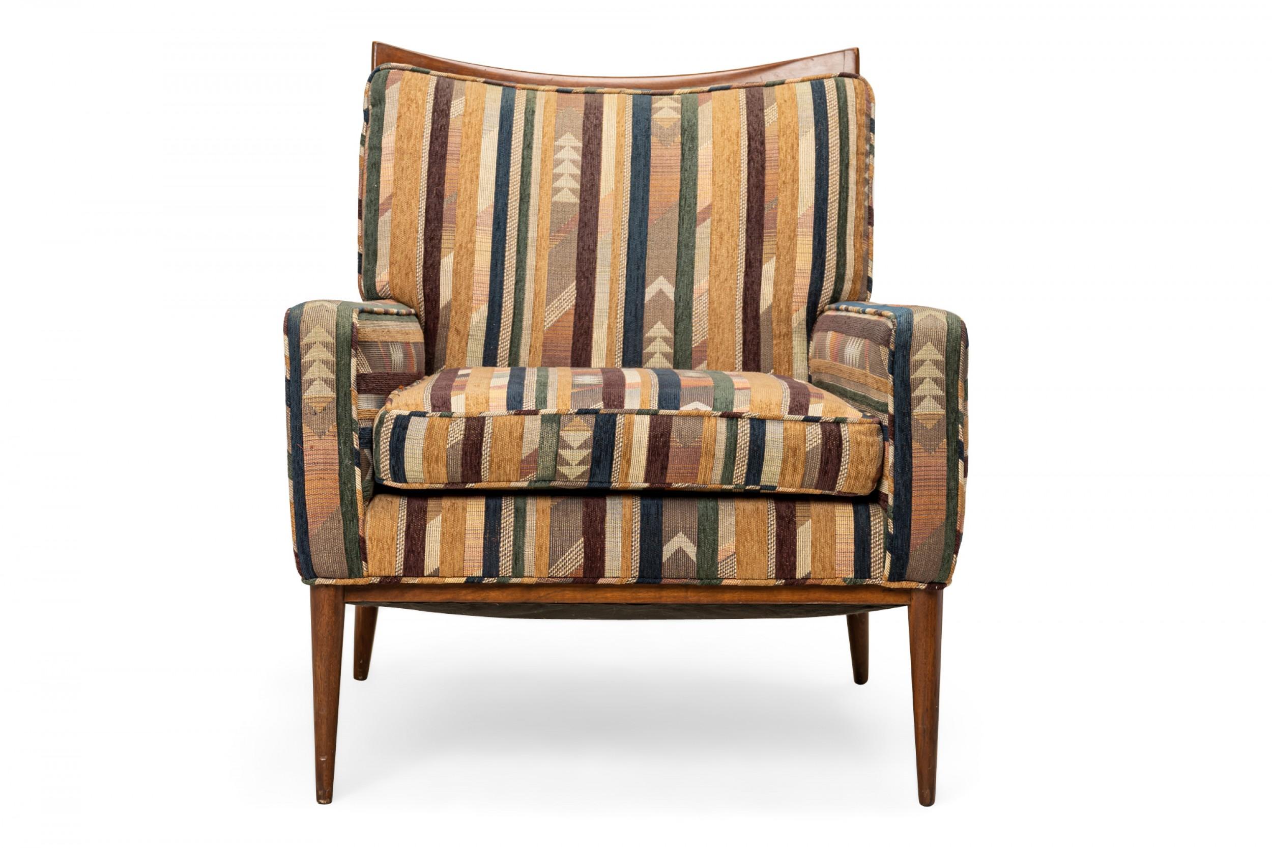 American Mid-Century lounge / armchair with a walnut frame with a scooped back rail and multi-colored geometric patterned and striped fabric upholstery, resting on four tapered dowel legs. (PAUL MCCOBB FOR DIRECTIONAL).