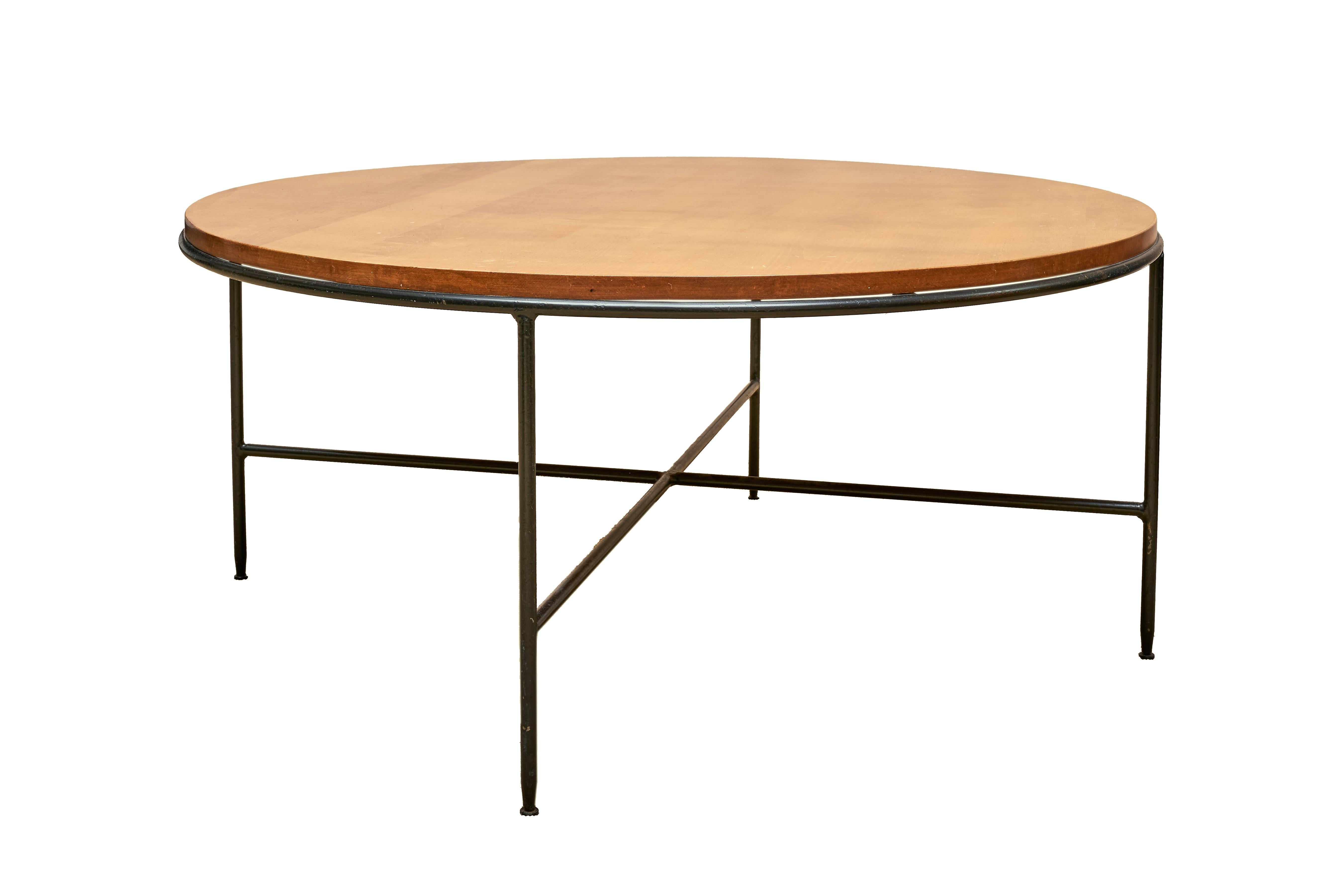 This Paul McCobb Round Coffee Table was crafted for the renowned Wichendon Furniture Company and is a timeless piece of mid-century design. This exceptional table showcases the combination of a solid birch top and a wrought iron base, resulting in a