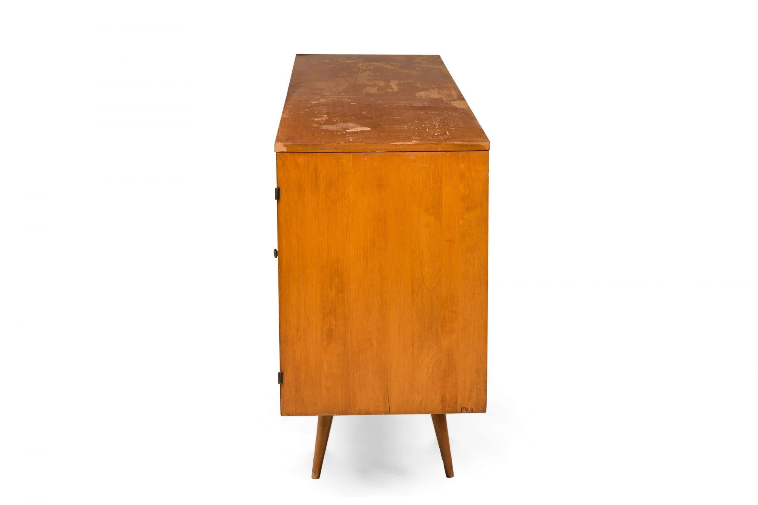 Server/armadio rettangolare in legno biondo della metà del secolo scorso (circa anni '50, Planner Group) 20 cassetti totali: 5 con frontali sagomati su ciascun lato nascosti da ante a cerniera, 4 cassetti stretti sul piano superiore e 2 colonne di