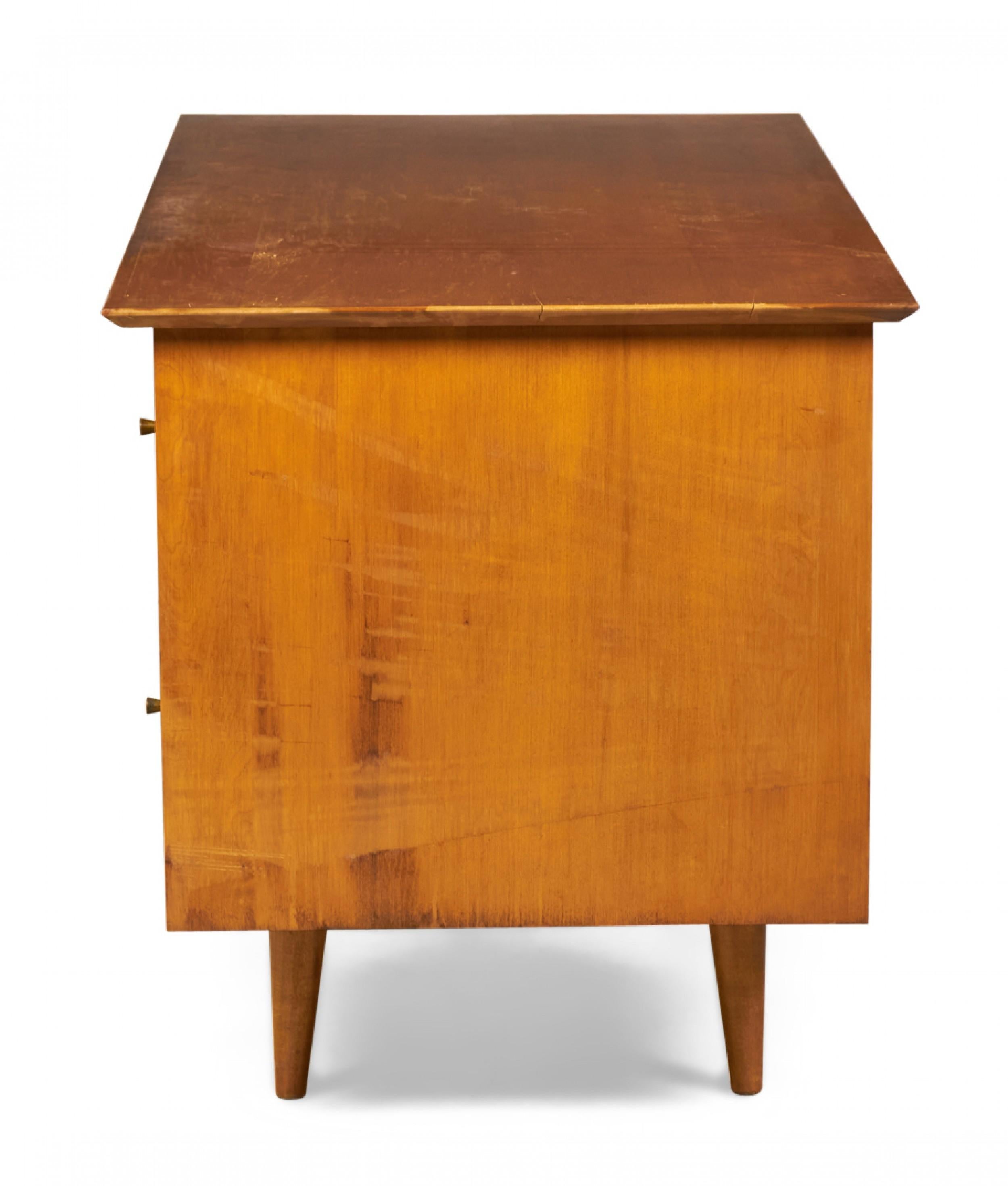 American Mid-Century (circa 1950) maple double pedestal desk with vintage finish and solid brass 