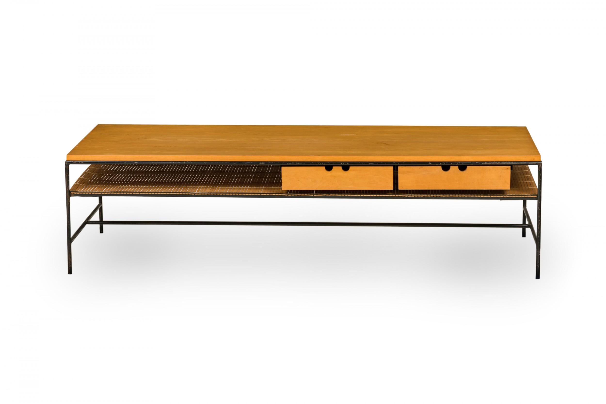 American Mid-Century 'Planner' coffee / cocktail table with a rectangular blond wood top with two drawers and a shallow shelf below, supported by a black iron frame with a stretcher base. (PAUL MCCOBB FOR WINCHENDON FURNITURE COMPANY)(Similar table: