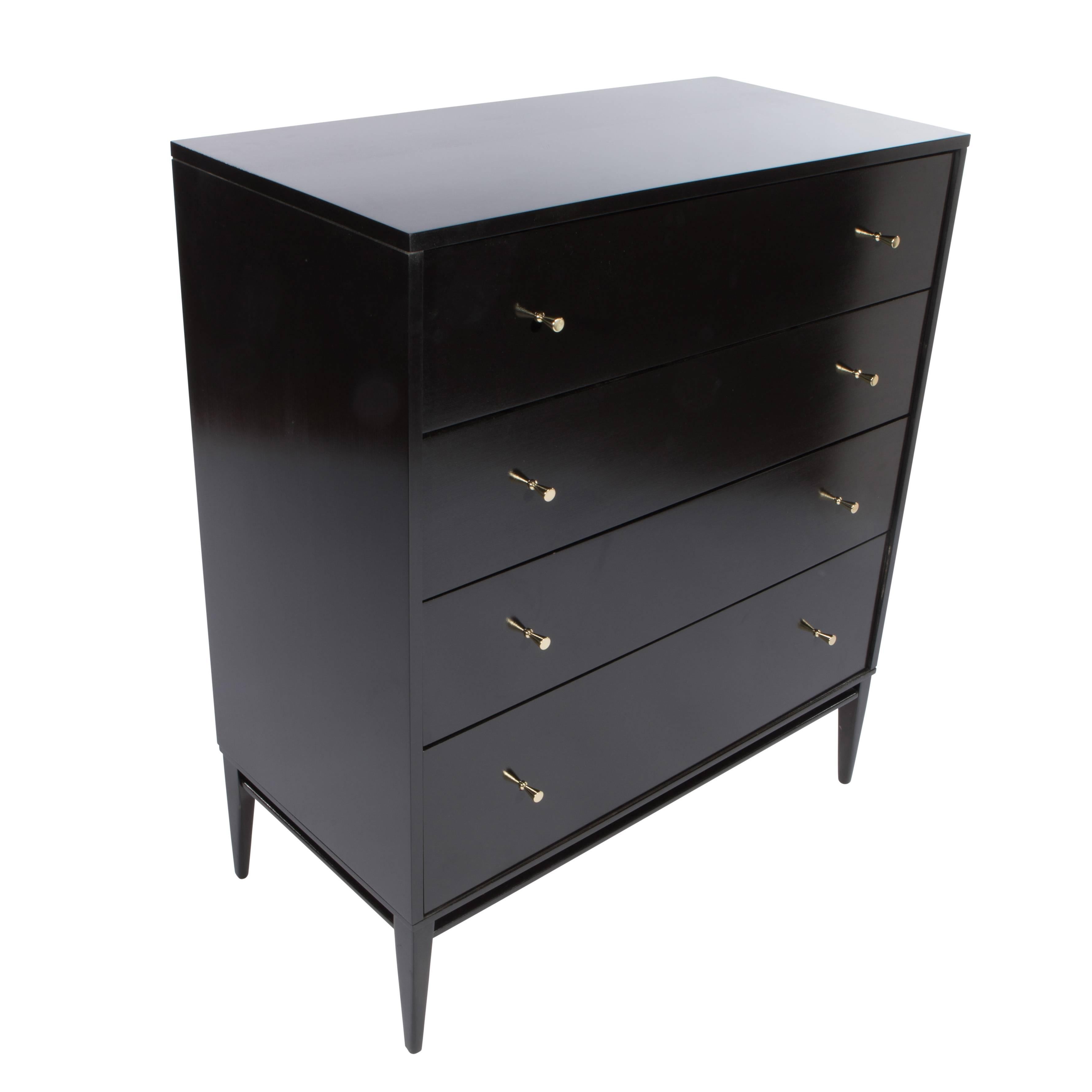Four-drawer dresser supported by an elegantly tapered leg at each corner, part of Paul McCobb's Planner Group for Winchendon Furniture Co. The original conical brass pulls have been newly polished and lacquered. The maple has been restored with an
