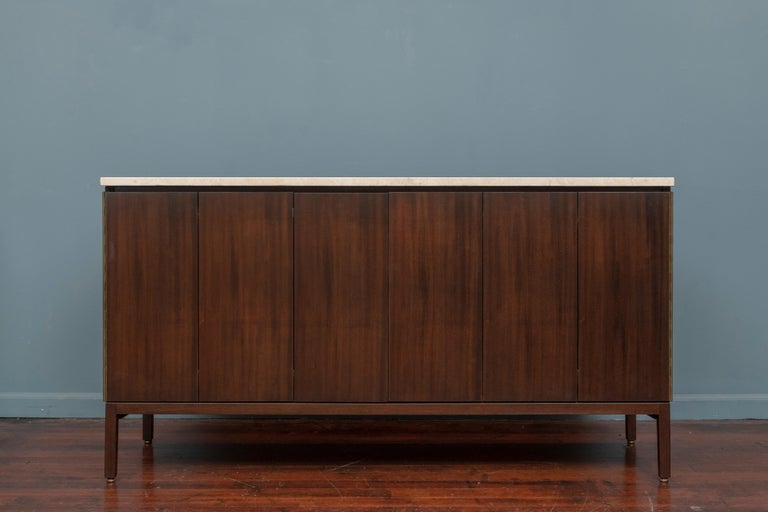 Paul McCobb design cabinet or credenza for his Irwin Collection. Classic American modern aesthetic media cabinet or smaller credenza having clean lines, tri-fold doors a single drawer and adjustable shelves. 
Newly refinished in a dark mahogany